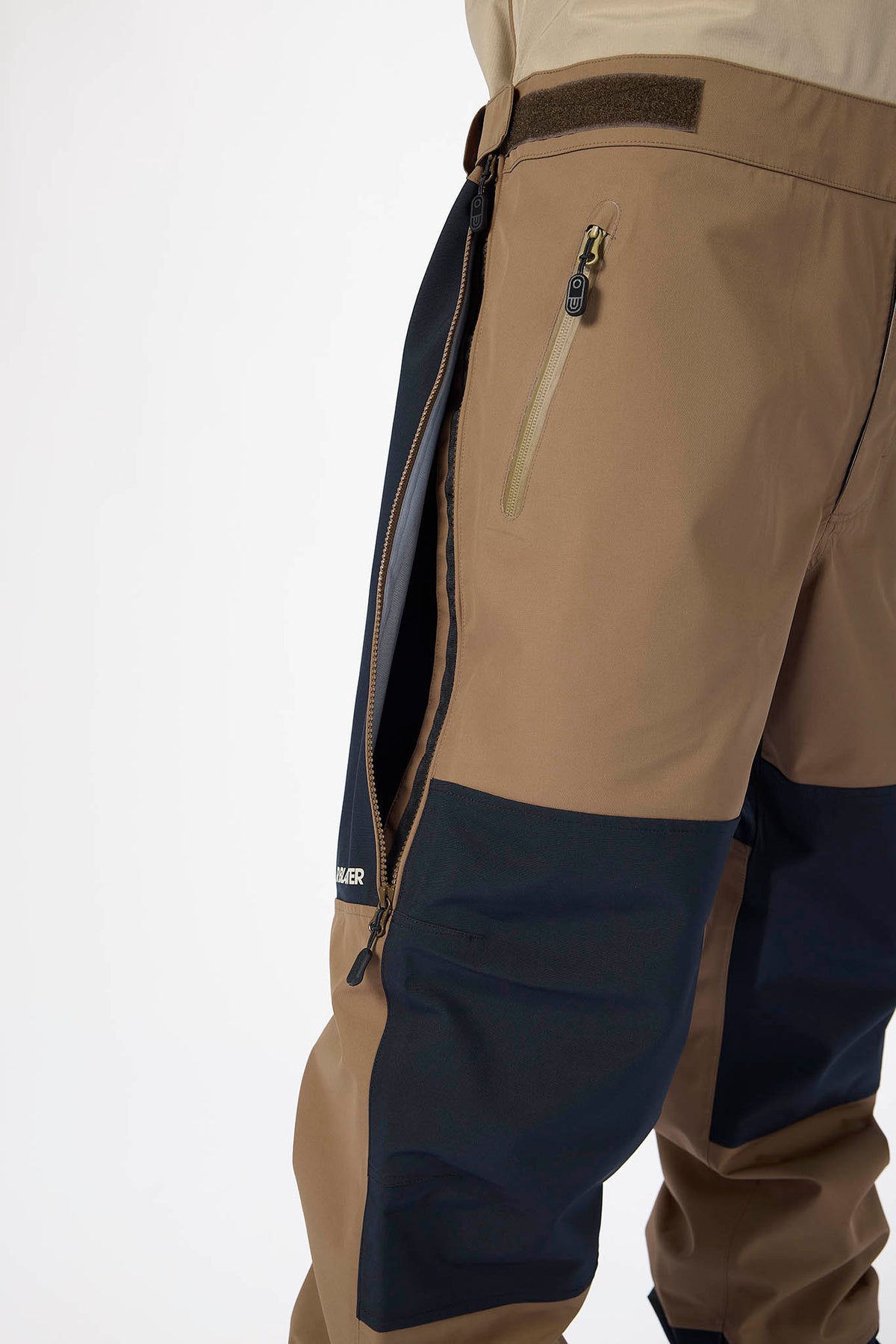 Close-up of a beige and navy pants with a brand logo on a white background