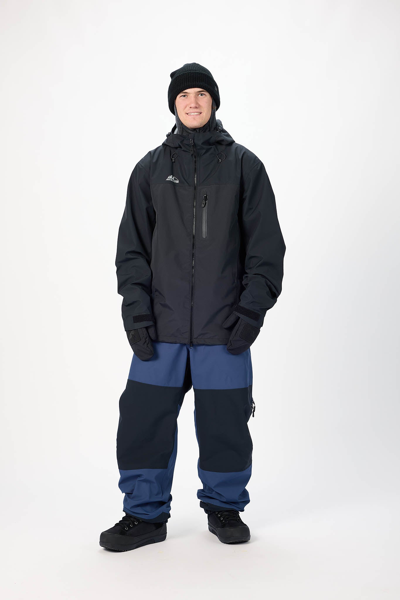 Person wearing a black jacket and blue pants on a white background