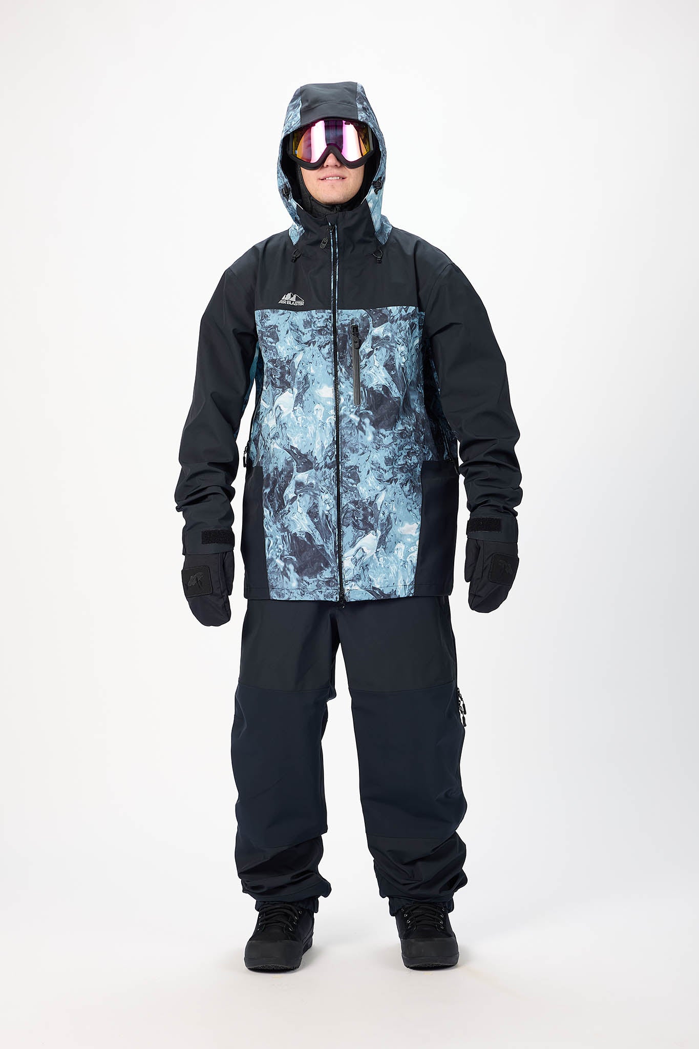 Person wearing a black snowsuit with a patterned chest area on a white background