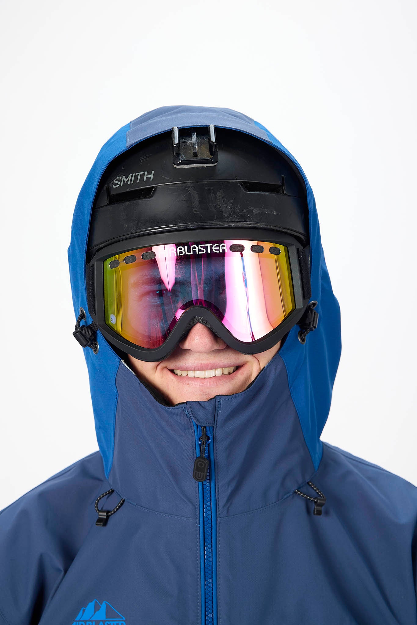 Person wearing a blue hooded jacket and Smith helmet with goggles on a white background