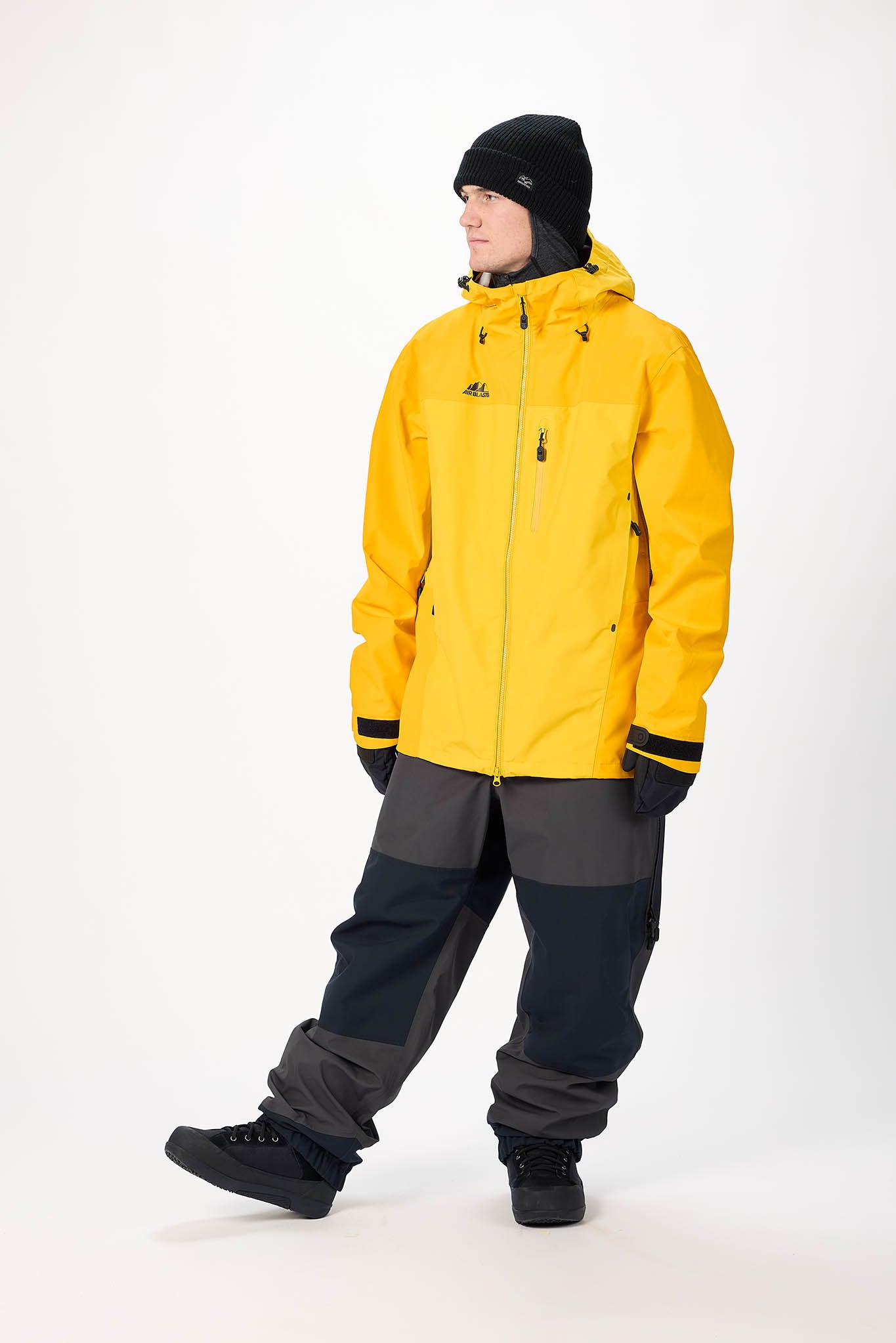 Person wearing a yellow jacket and gray pants on a white background