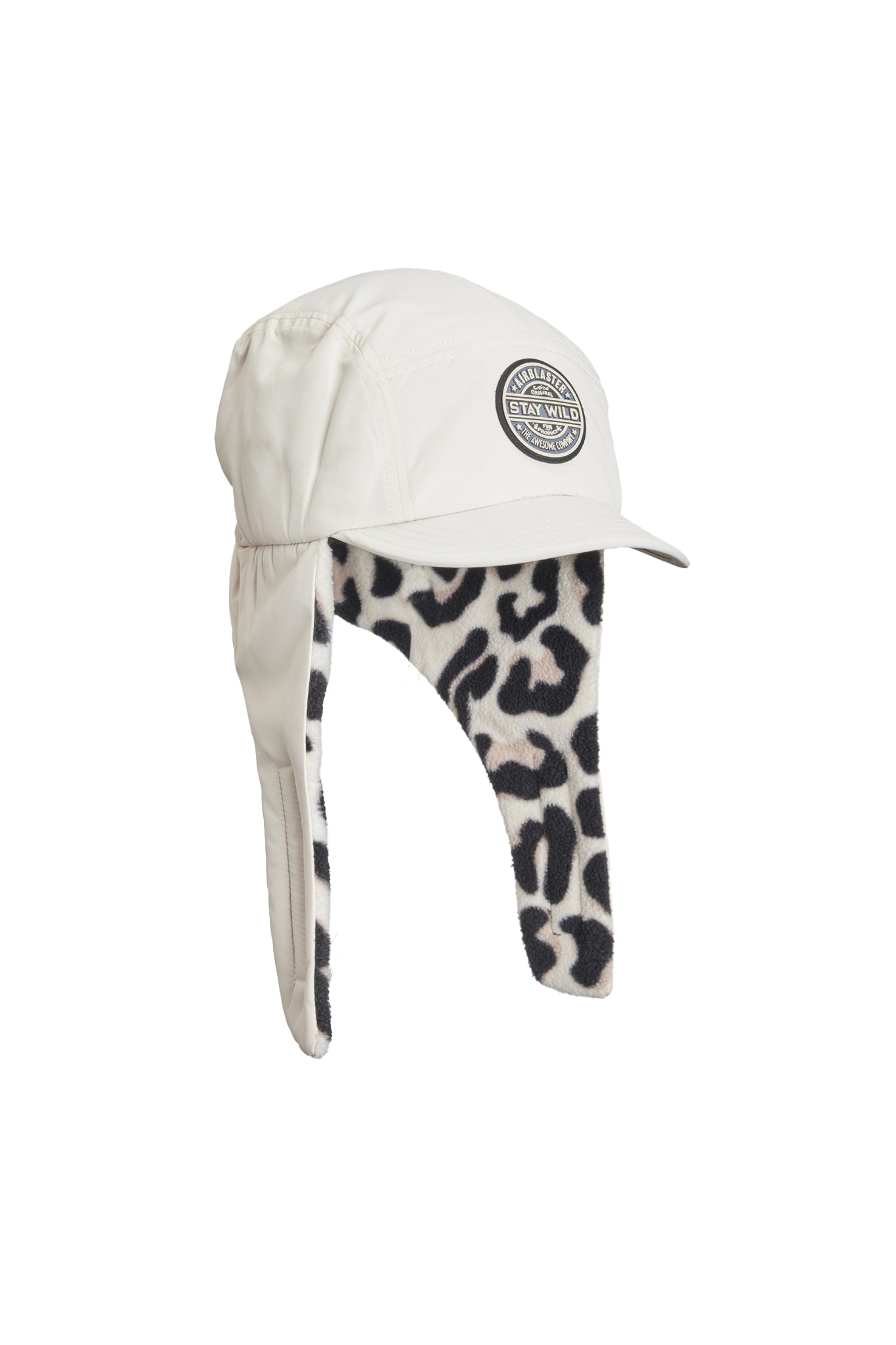 A cream-colored aviator-style cap with attached ear flaps and a black-and-cream leopard print lining, featuring a circular embroidered logo patch on the front.