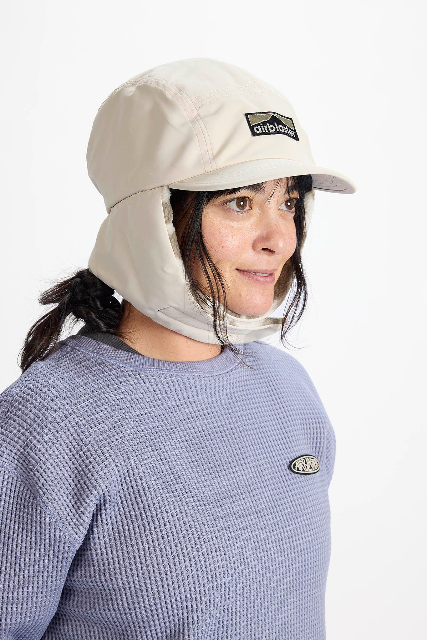 A woman in profile wearing a white outdoor sun hat with a built-in neck flap and visor, set against a plain white background.