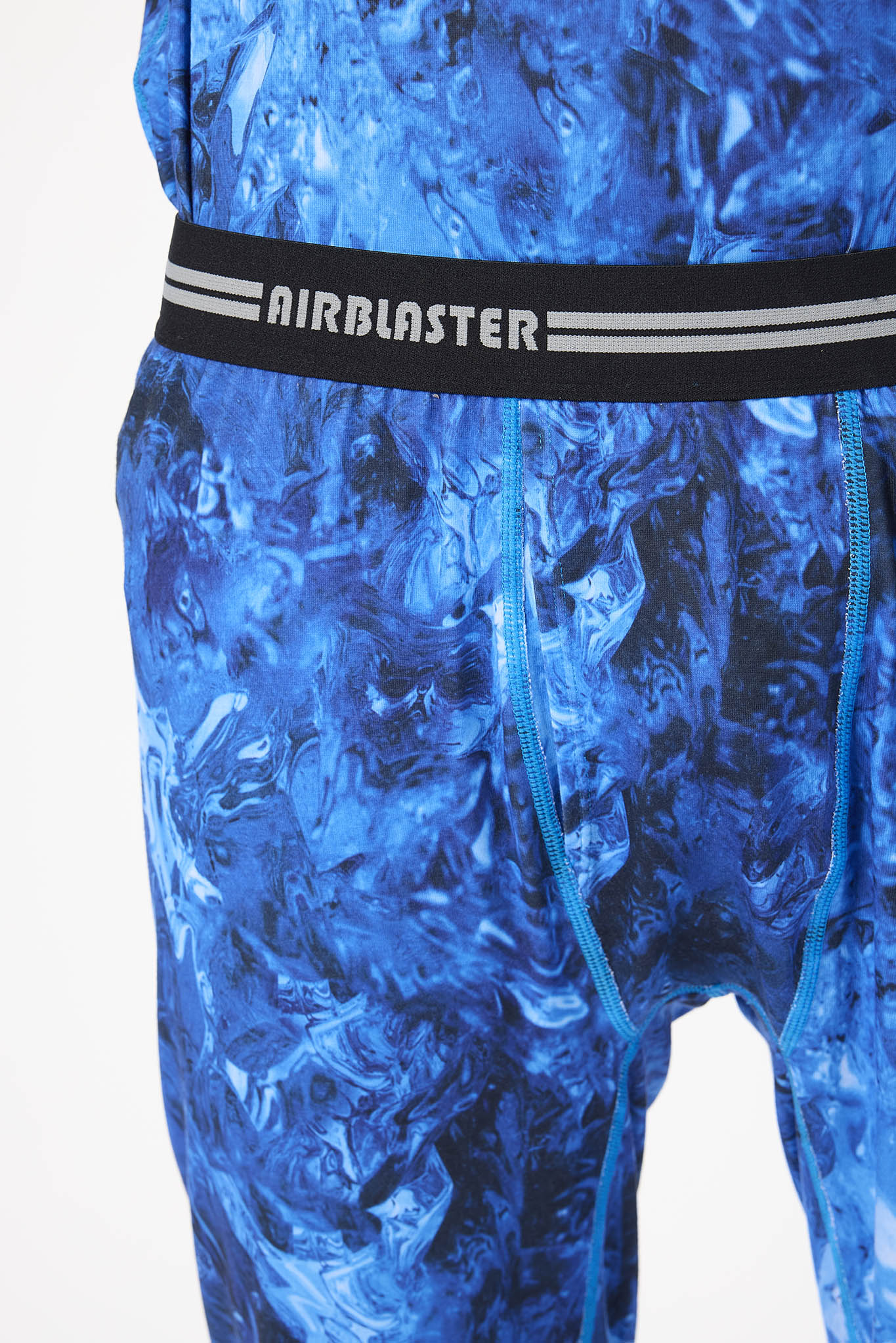 Close-up of a pair of blue patterned athletic shorts with a black waistband featuring the AIRBLASTER logo in white.