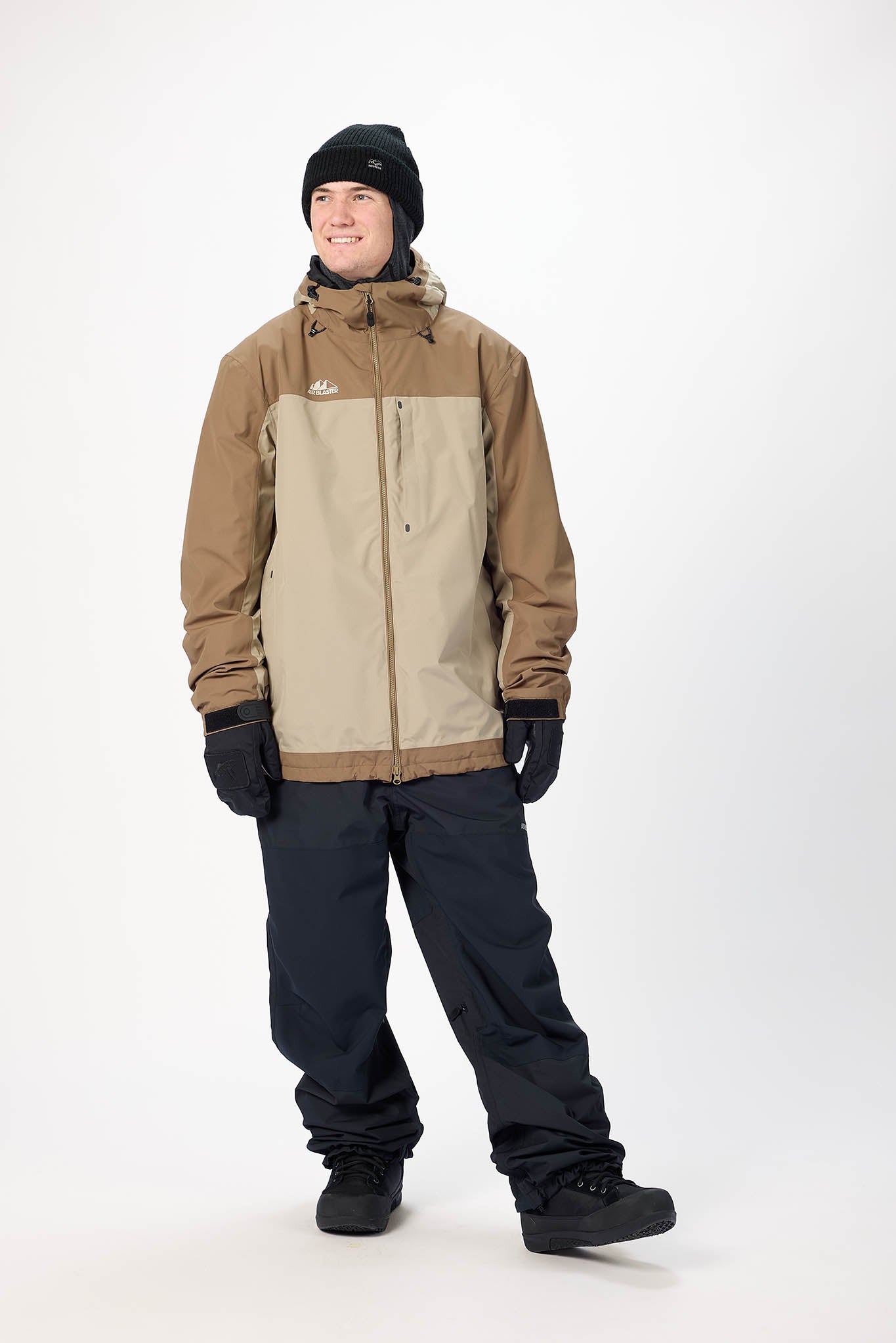 Person wearing a brown and beige jacket with black pants on a white background