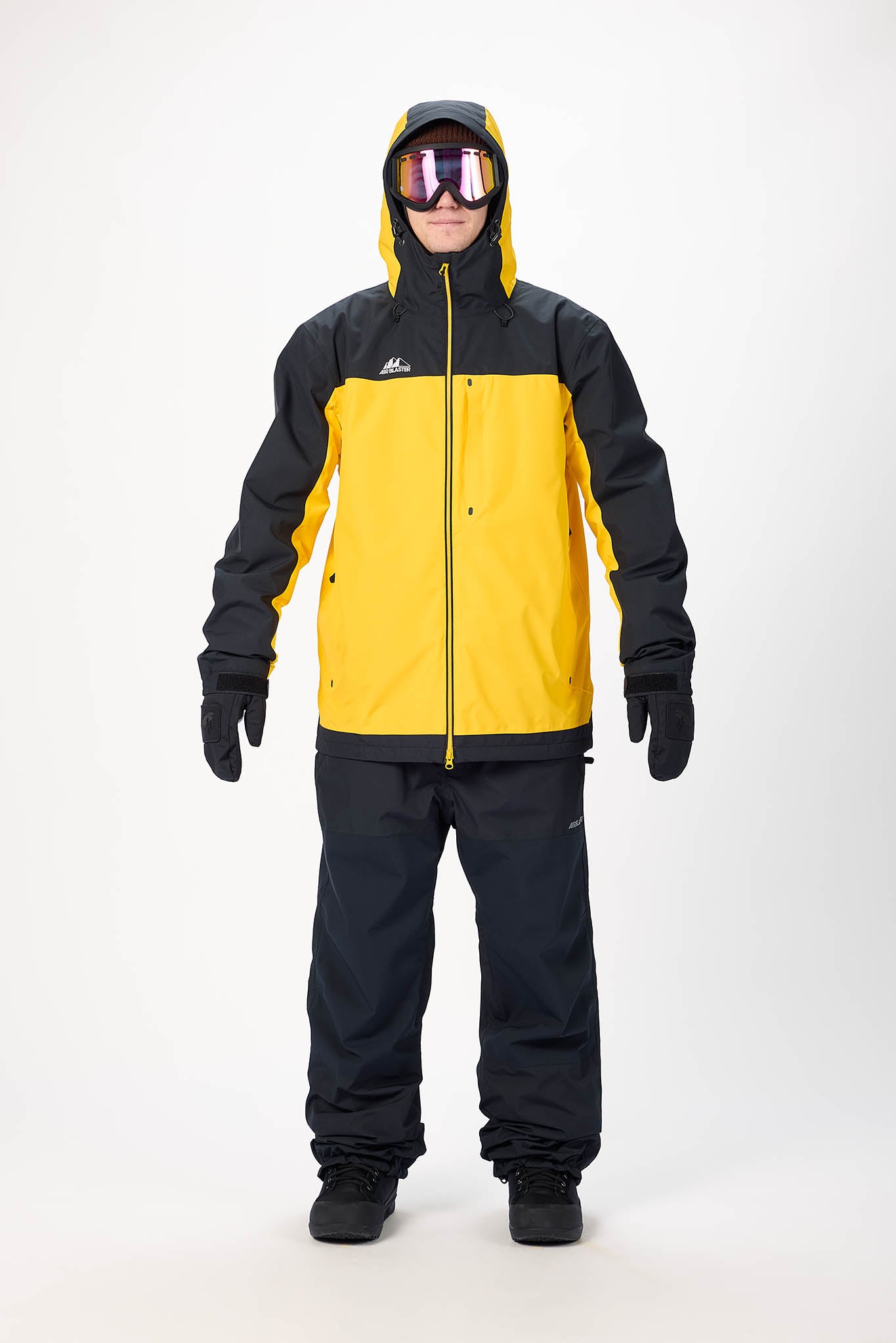 Person wearing a black and yellow snowsuit with goggles on a white background