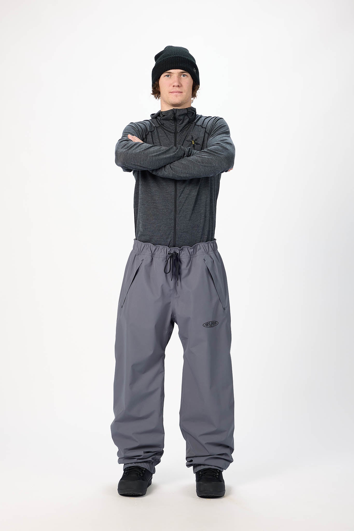Person wearing a gray snowmobile suit on a white background