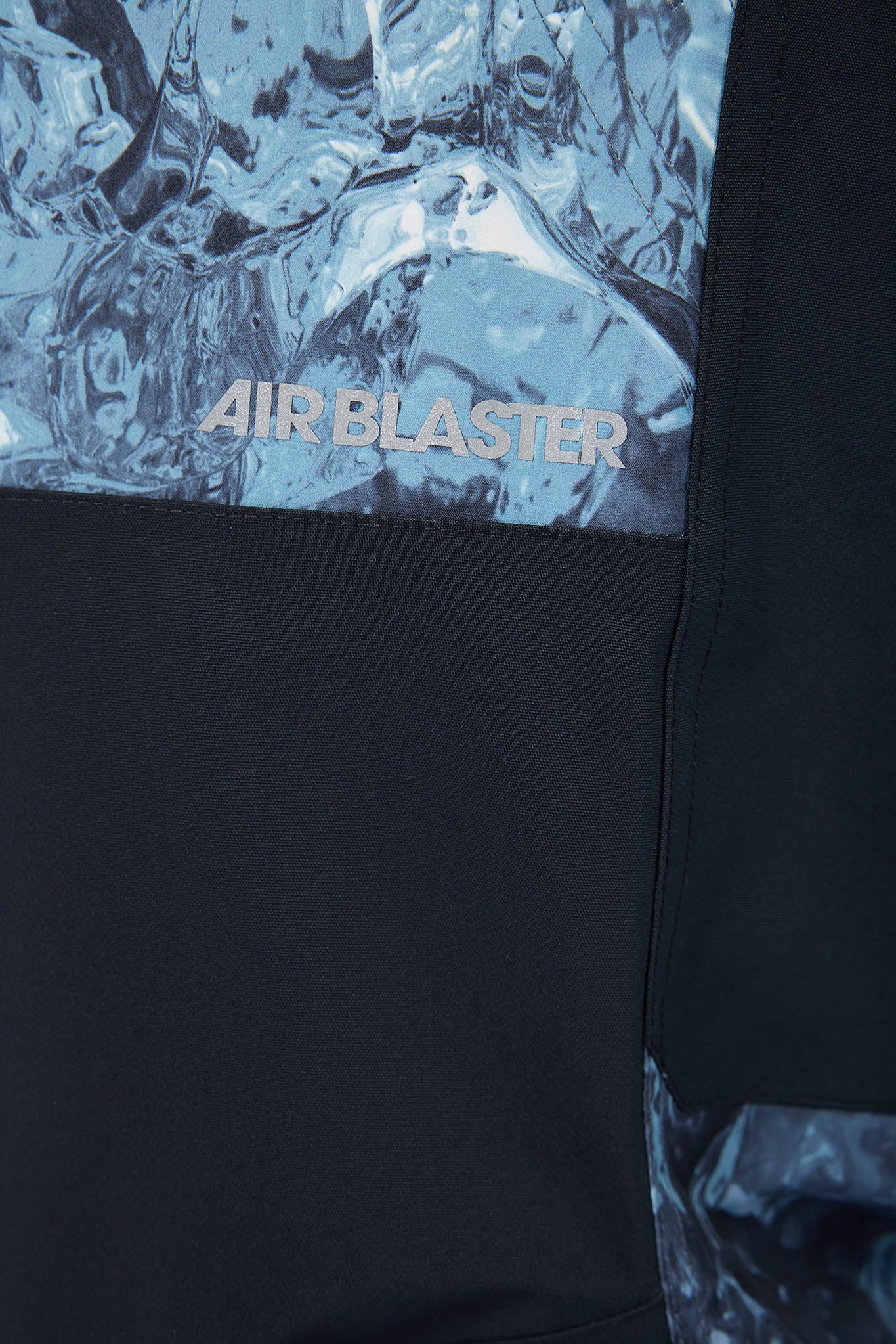 Black jacket with 'AIR BLASTER' logo on a textured blue background