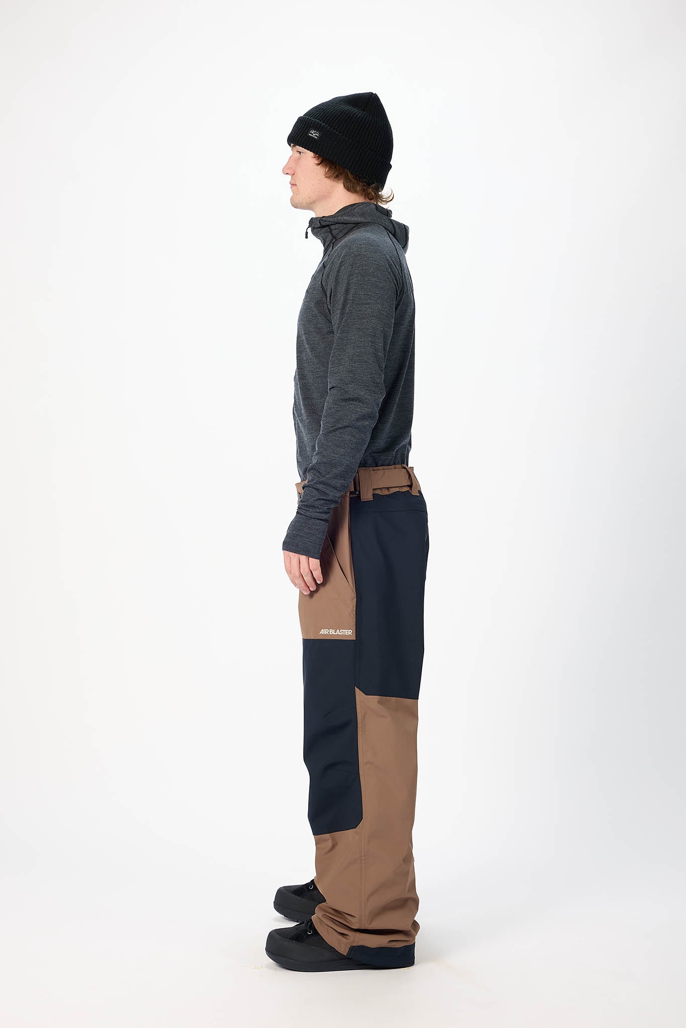 Person wearing a gray jacket, black pants, and a black beanie on a white background