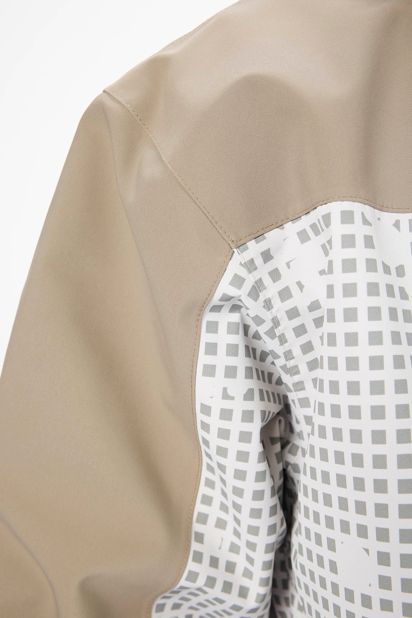 Close-up of a beige leather jacket with a white shirt underneath featuring a checkered pattern.