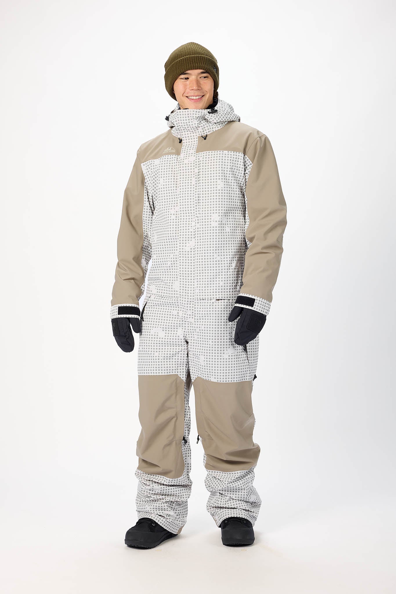 Person wearing a beige and white snowsuit on a white background