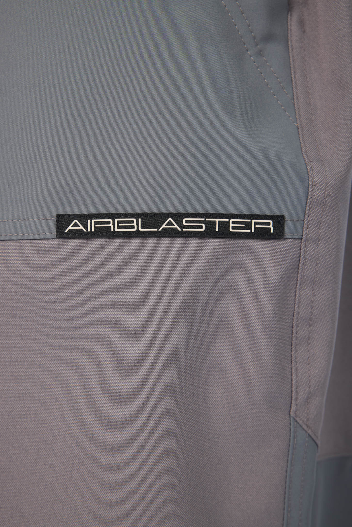 Close-up of a gray jacket with 'AIRBLASTER' branding.