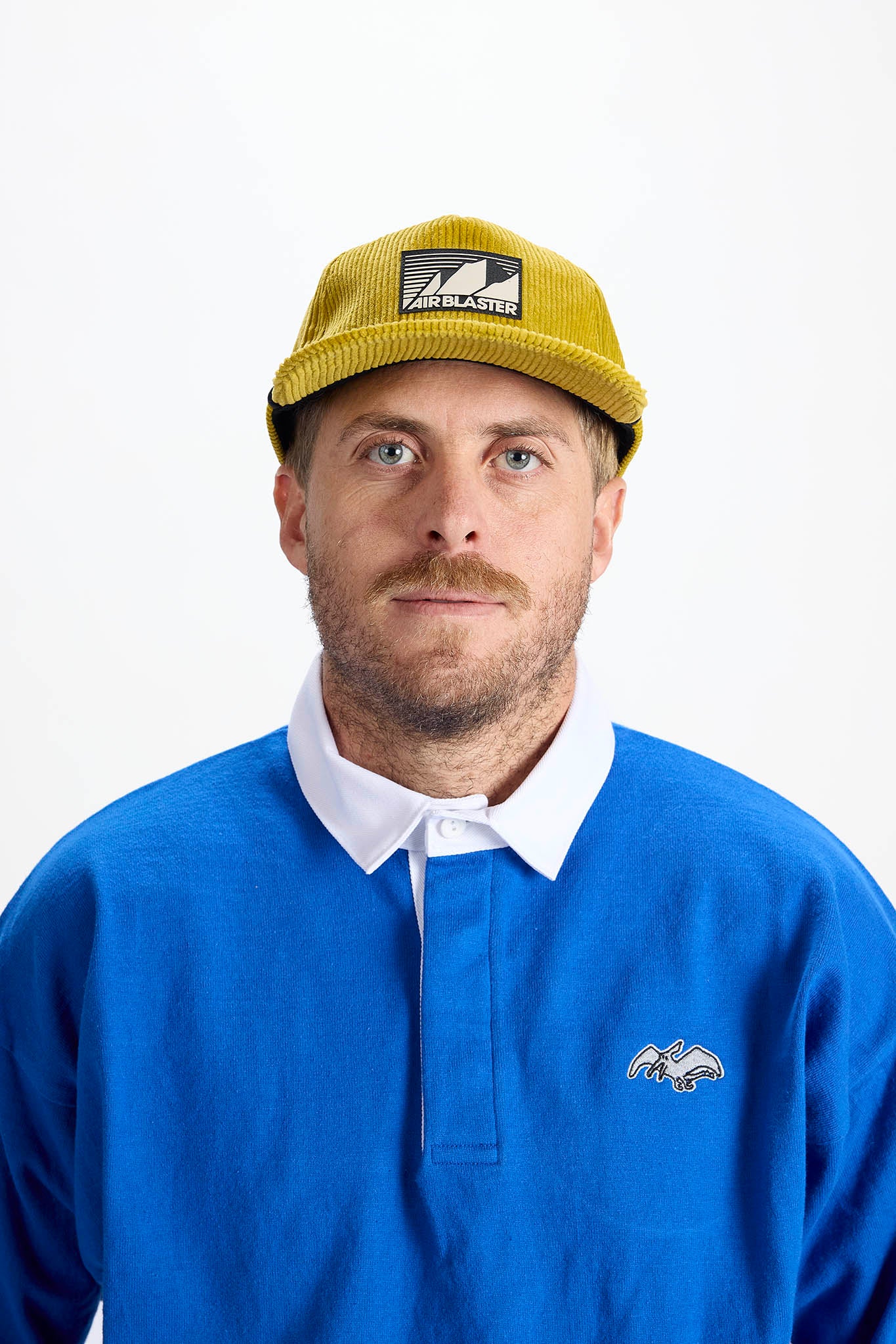 A woman wearing a yellow baseball cap, photographed against a plain white background.