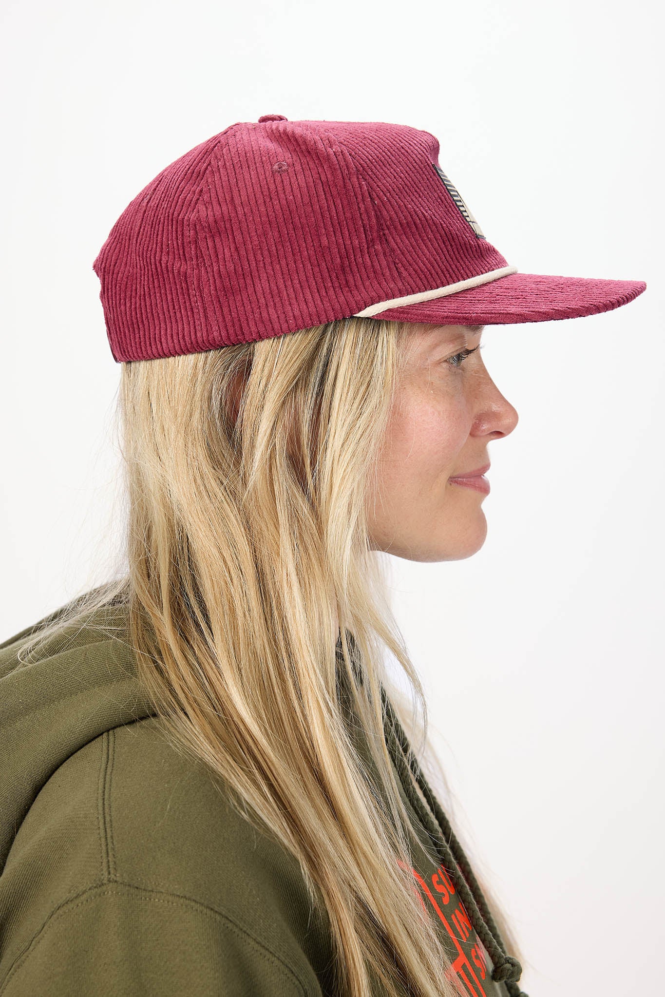 side profile of model wearing red baseball cap