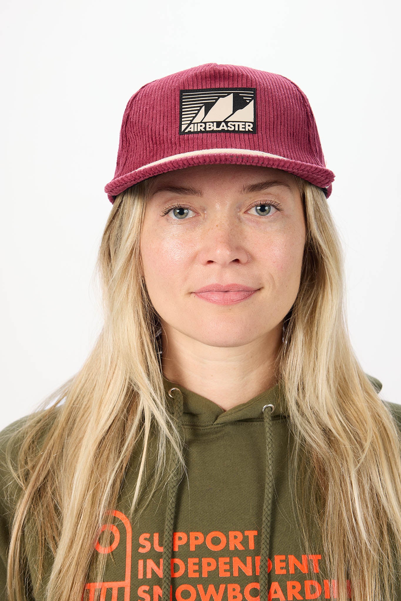 A woman wearing a red baseball cap, photographed against a plain white background.