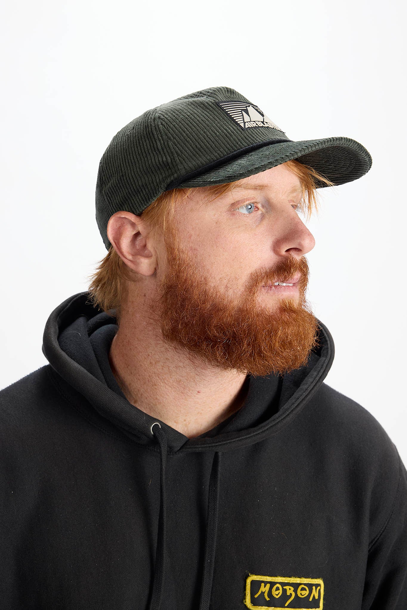 model wearing a green baseball cap with white background