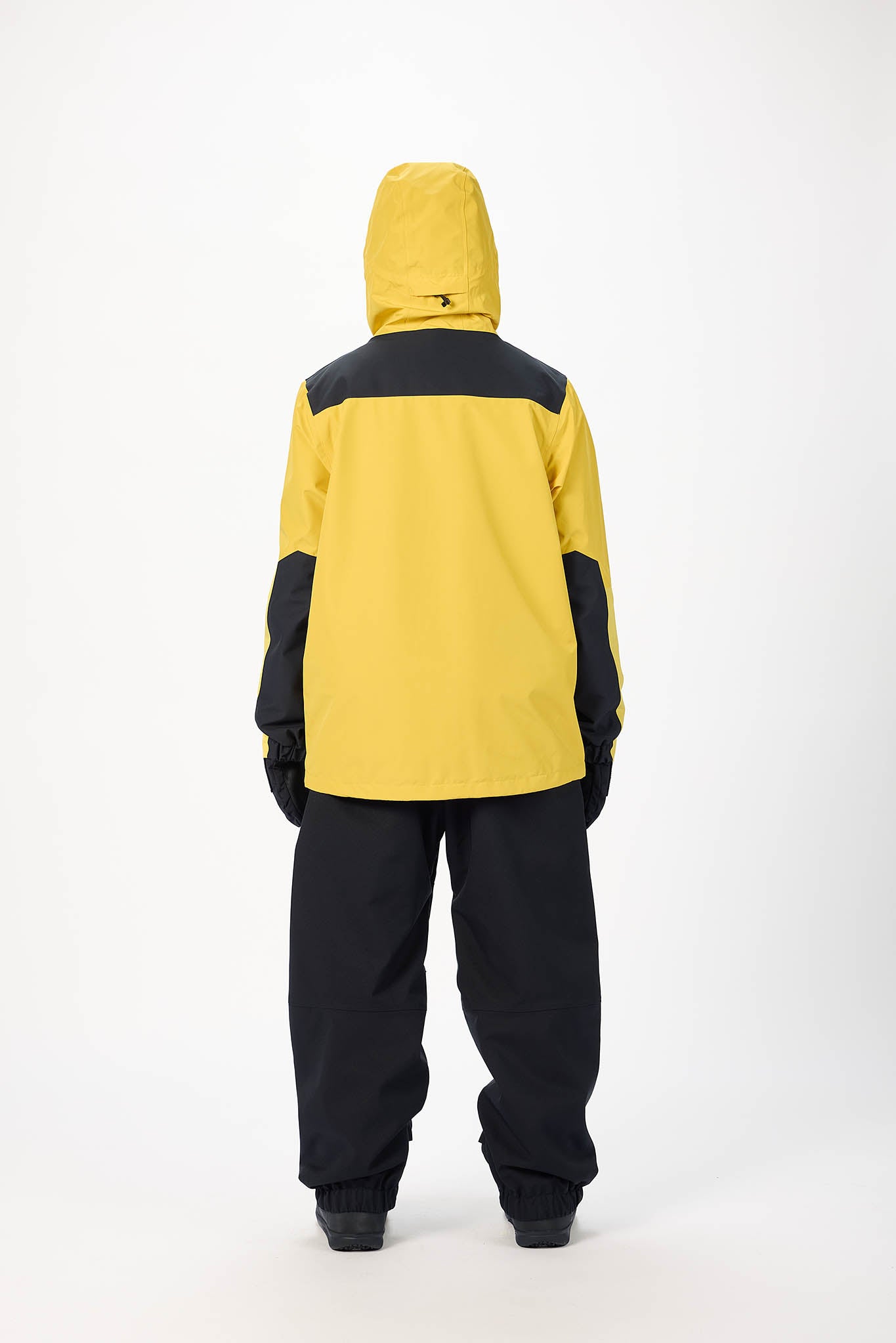 Person wearing a yellow and black snowsuit on a white background