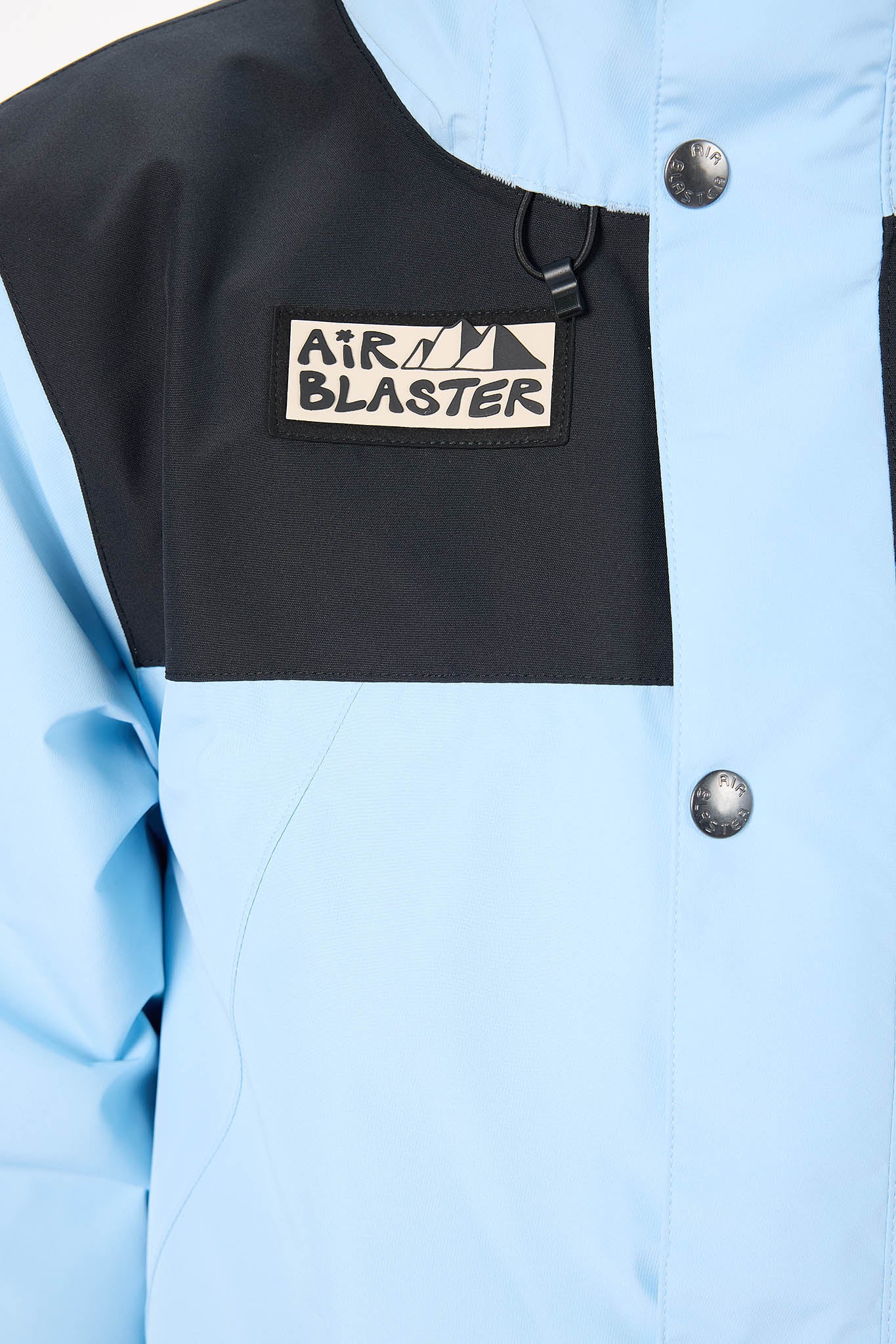 Light blue jacket with a black patch featuring 'Air Blaster' logo.