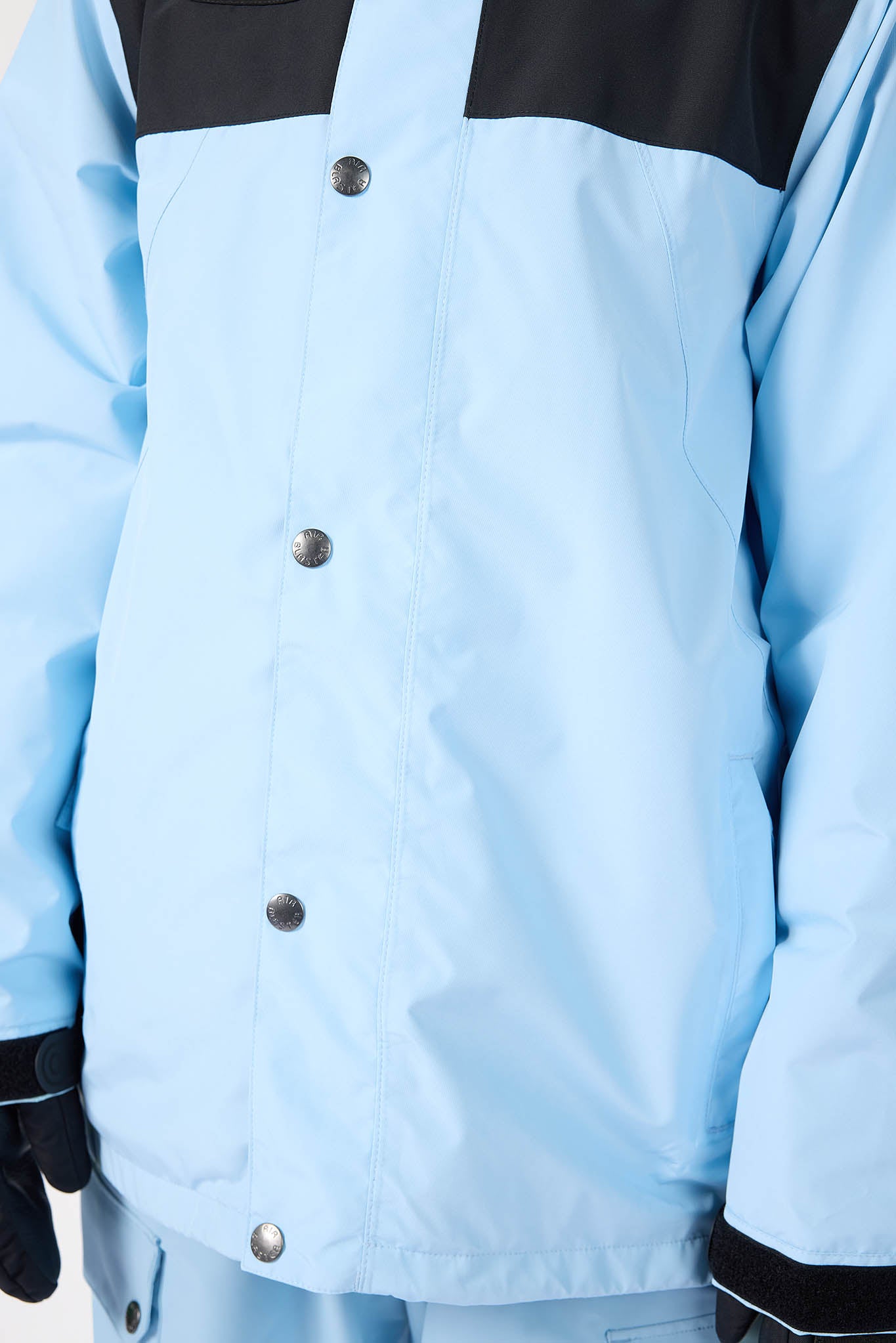 Light blue jacket with black accents and buttons on a plain background