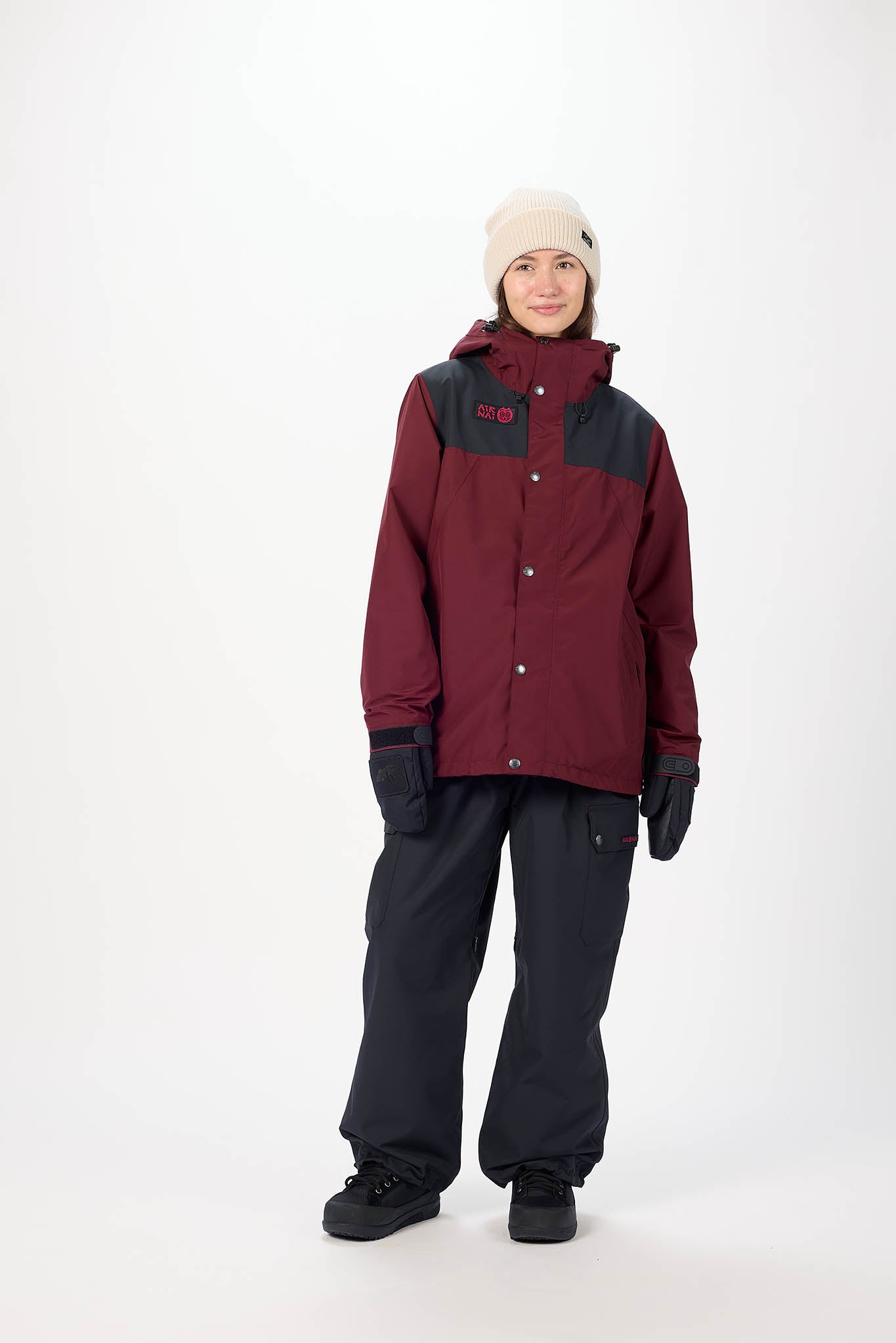 Person wearing a maroon and black jacket with a white background