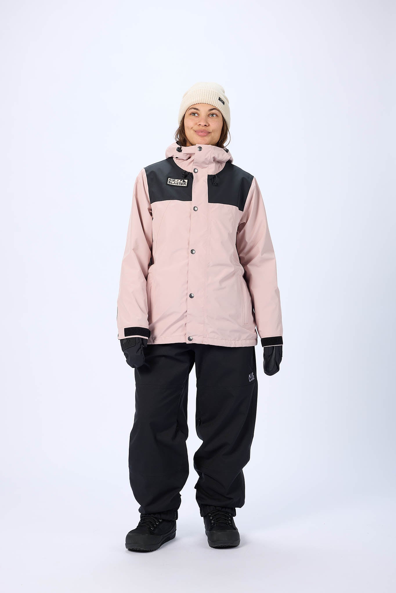 Person wearing a two-tone pink and black snowboard jacket and pants on a white background