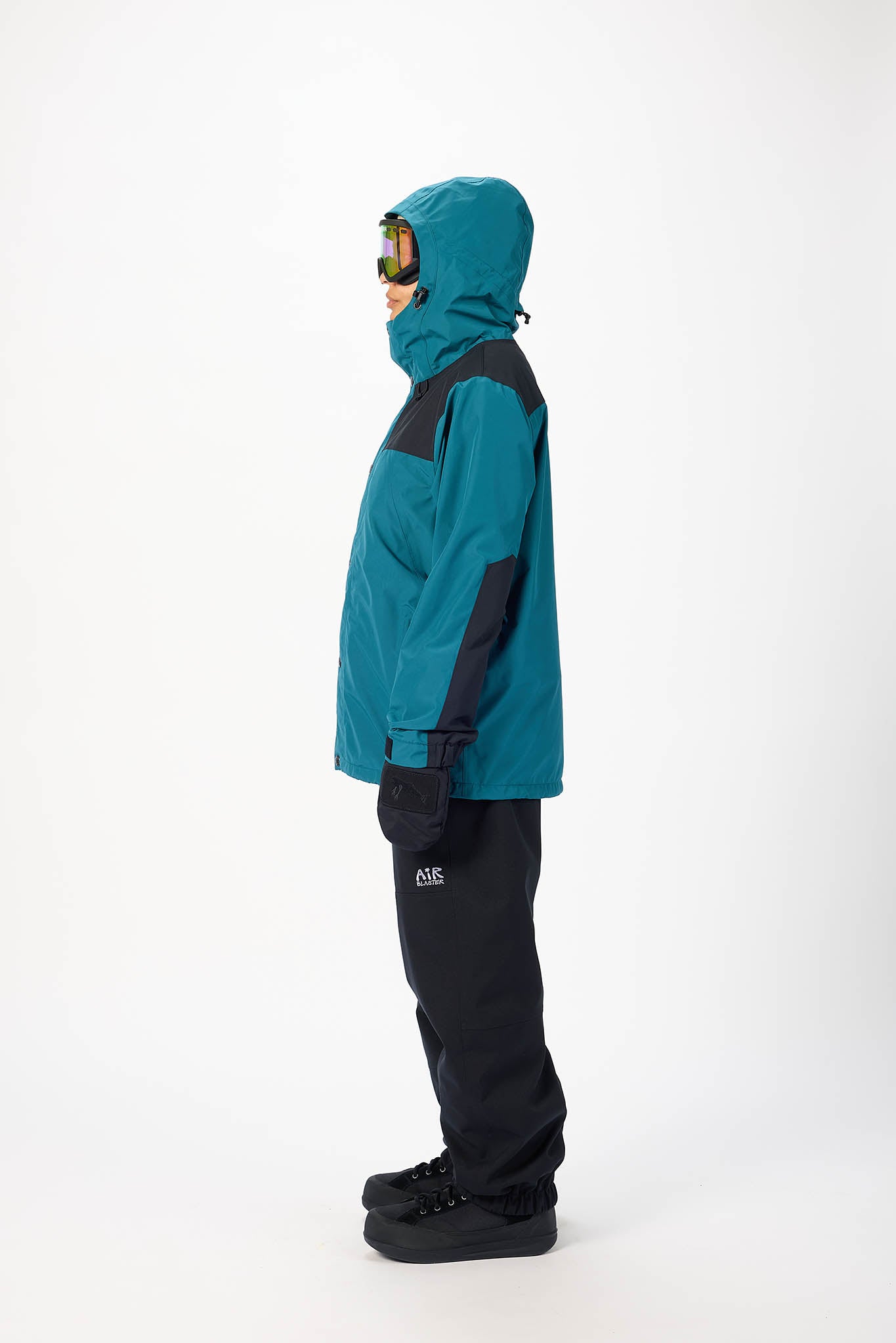 Person wearing a teal and black snowsuit on a white background