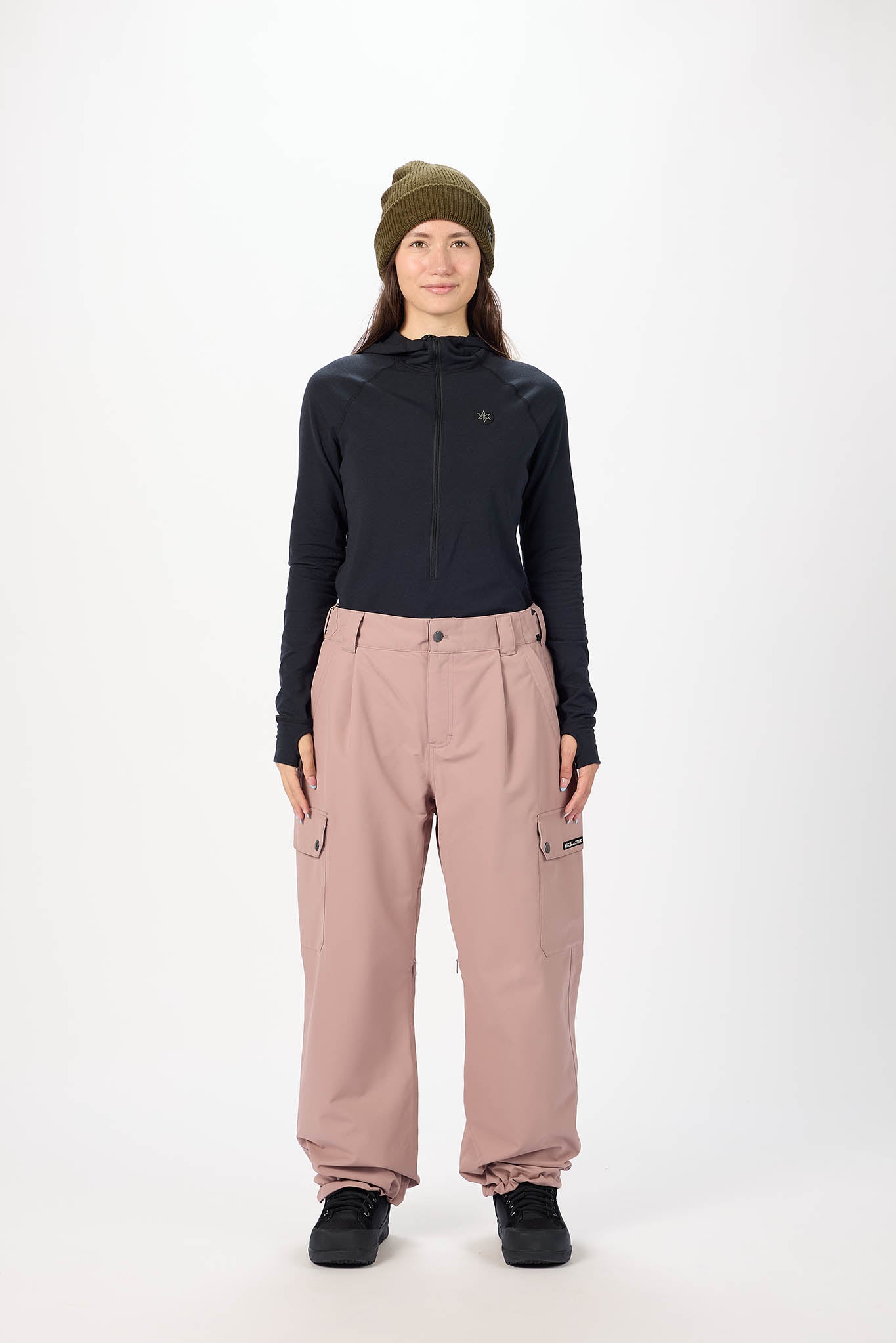 Person wearing a black jacket and pink pants on a white background