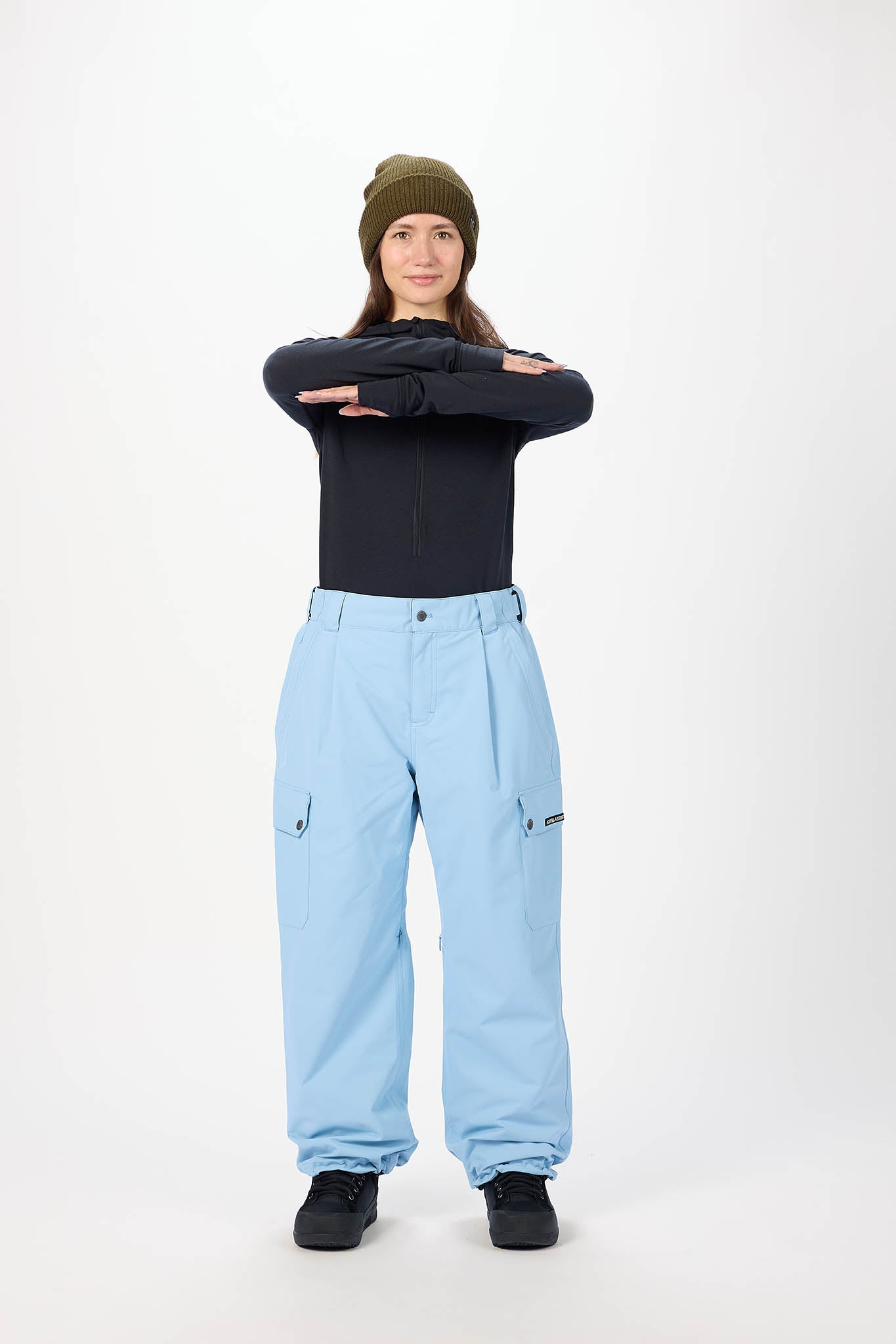 Person wearing a black top and light blue pants on a white background