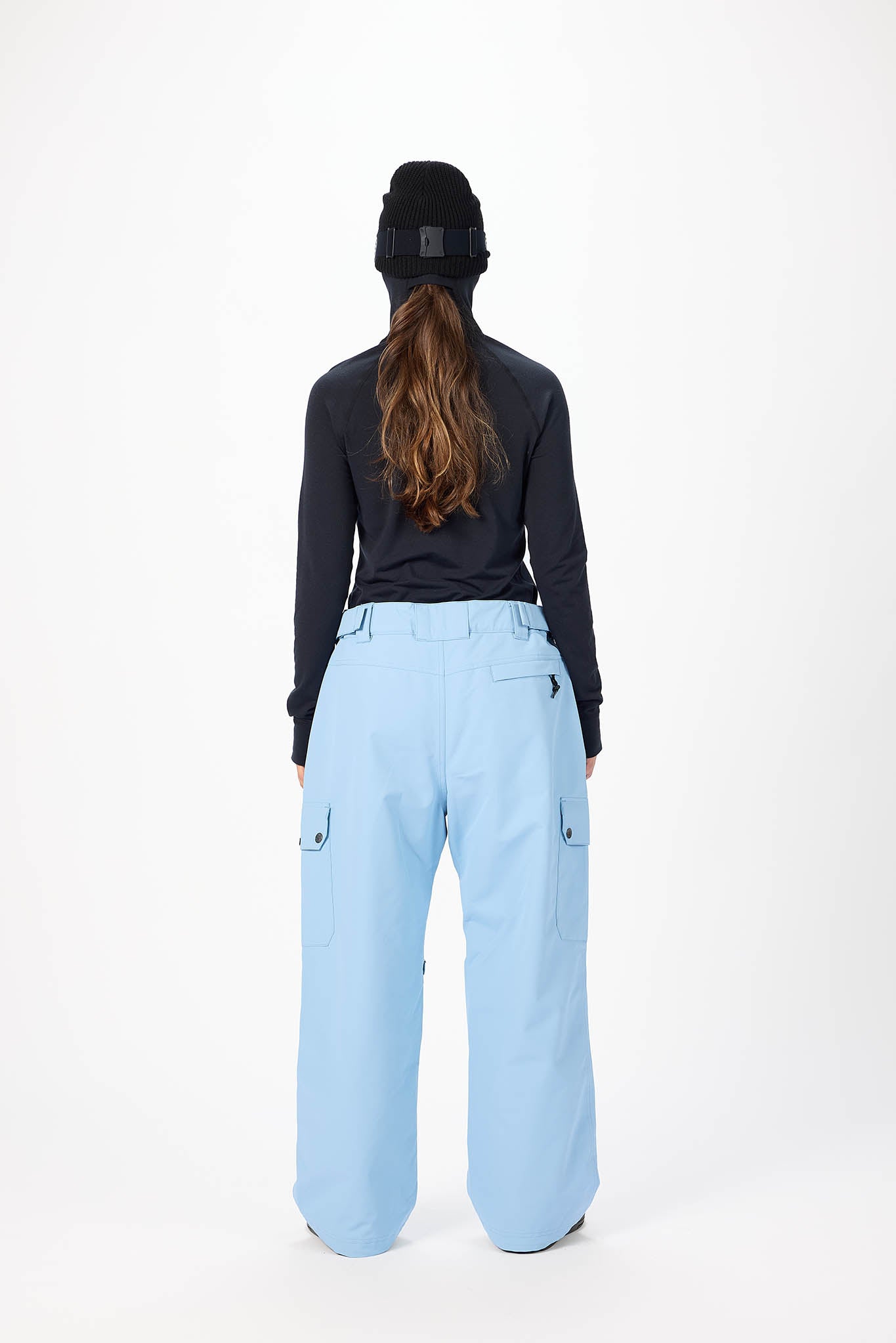 Person wearing a black top and light blue pants on a white background