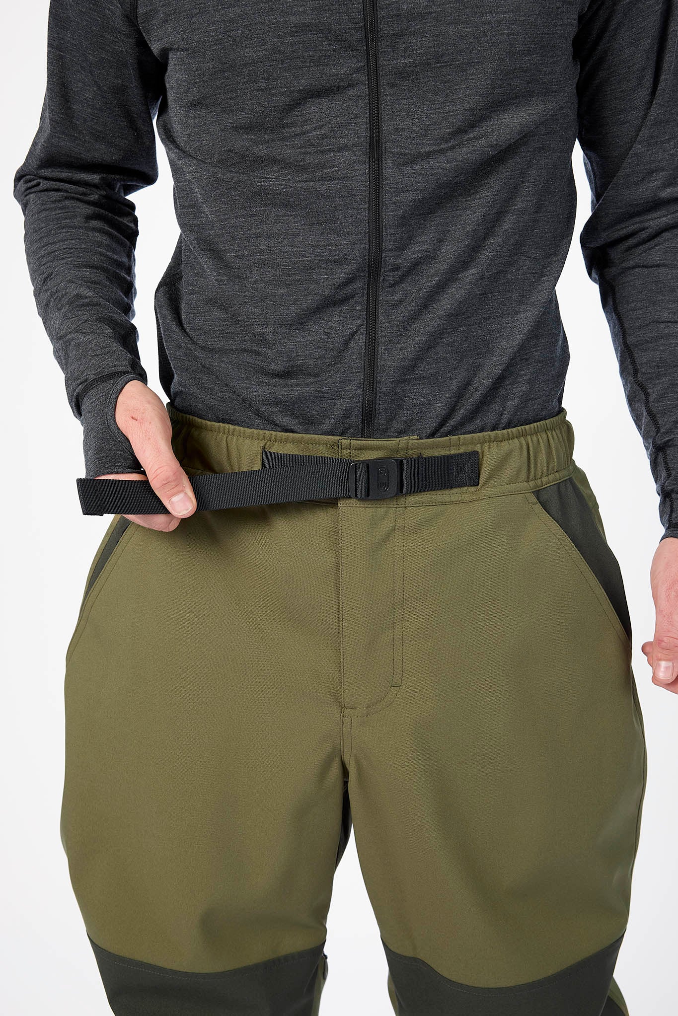 Person wearing a dark gray long-sleeve top and olive green pants with a black belt.