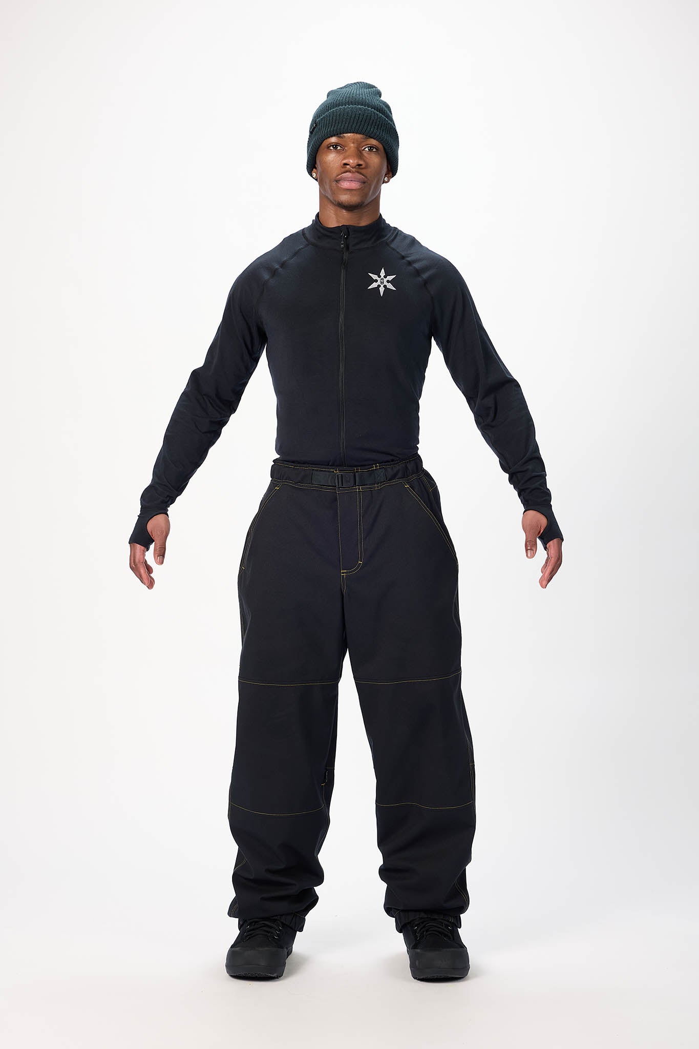 Person wearing a black snowsuit with a white logo on a white background
