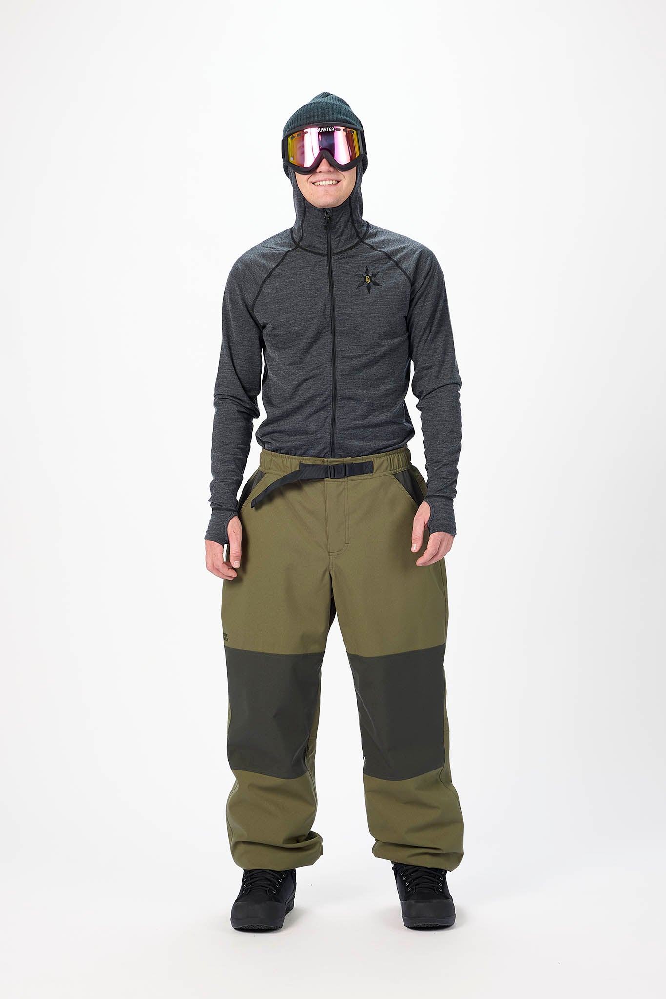 Person wearing a gray and green snowsuit with goggles on a white background