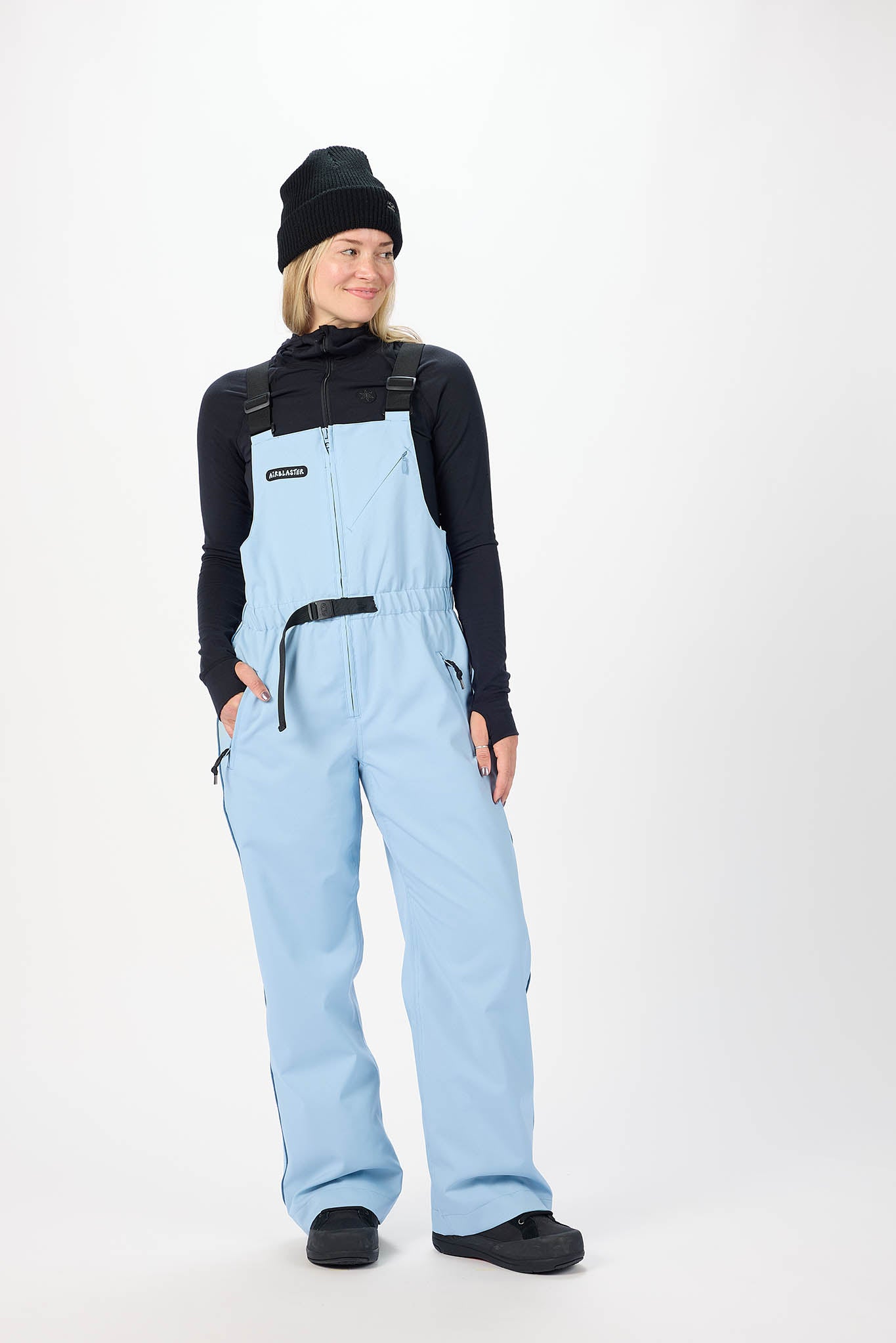 Person wearing light blue bib overalls on a white background