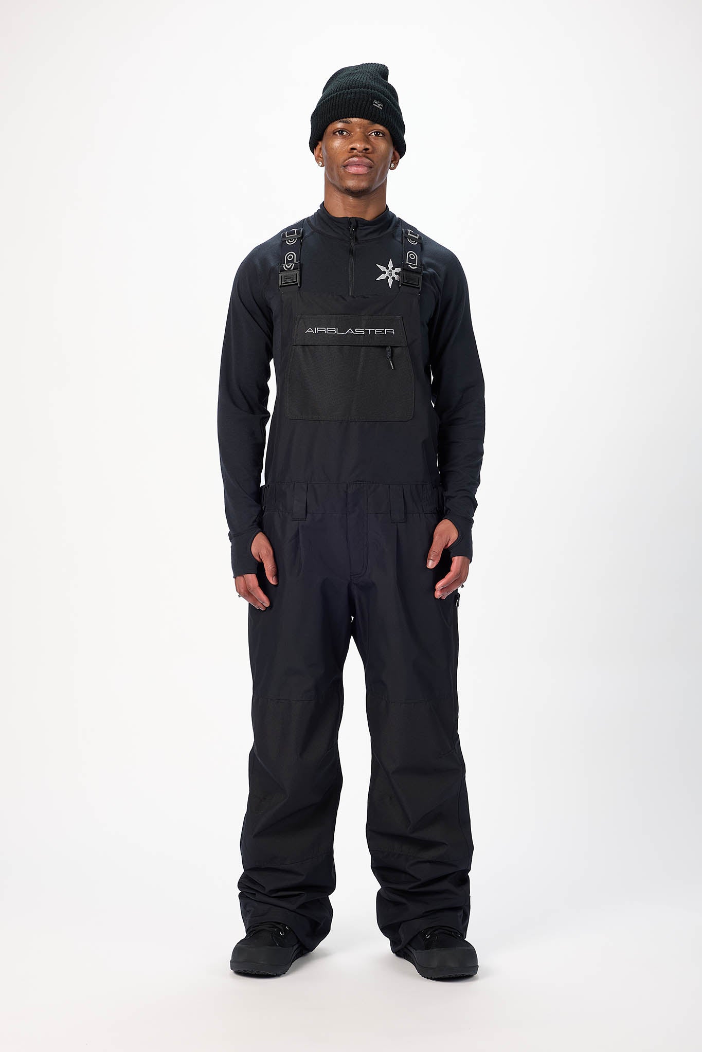 Person wearing a black snowmobile suit with a white background