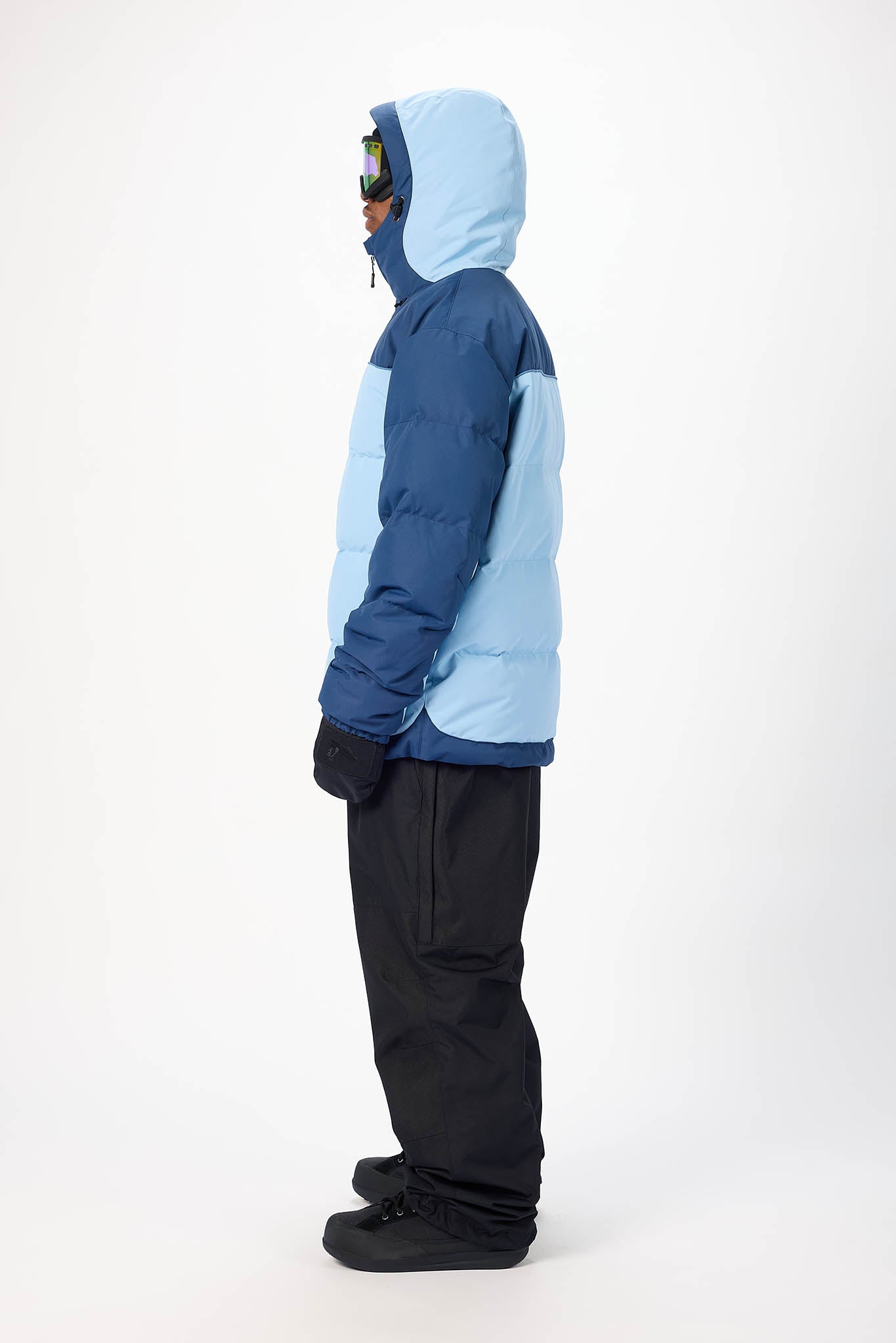 Person wearing a blue and navy jacket with a hood on a white background