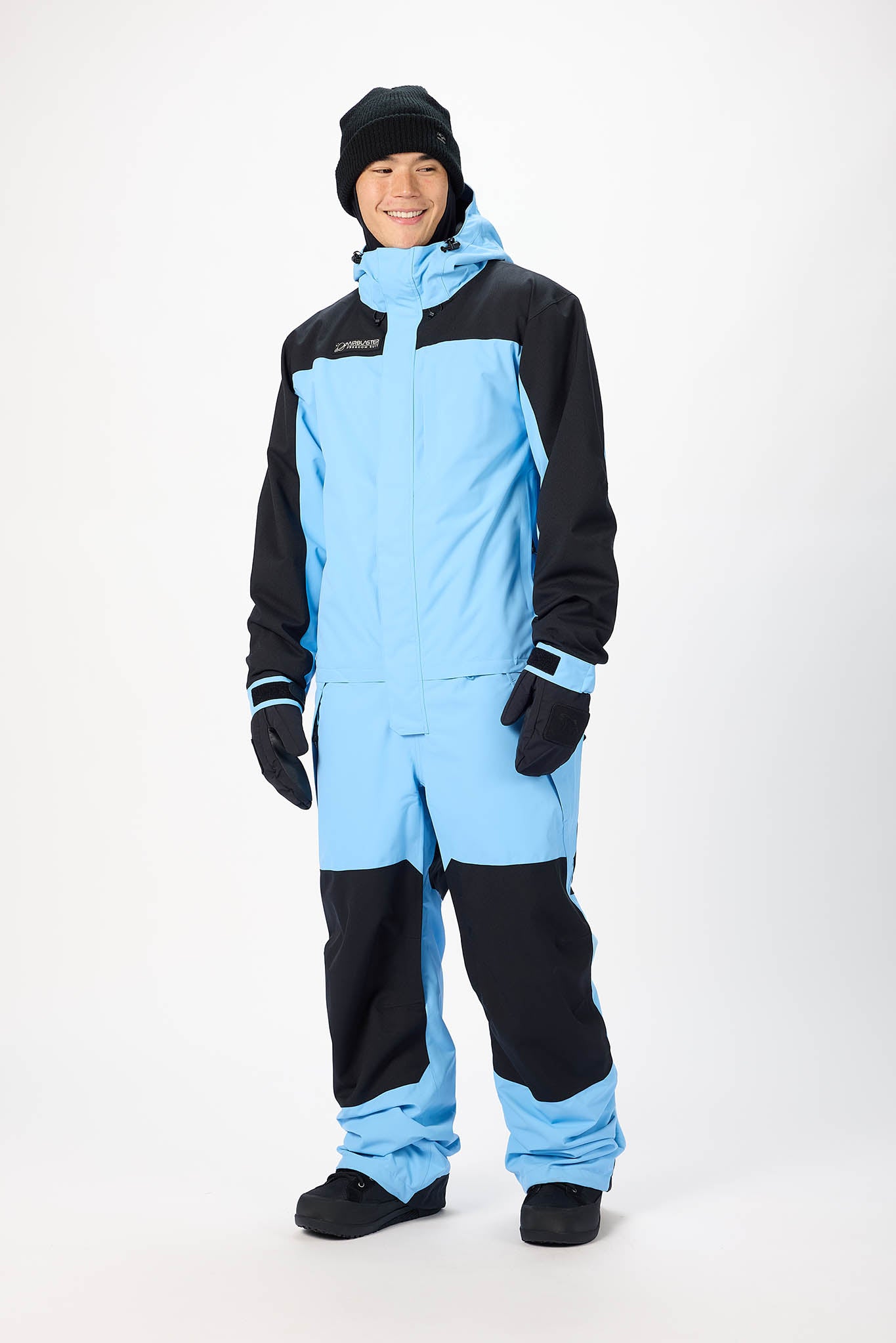 Person wearing a black and light blue snowsuit on a white background