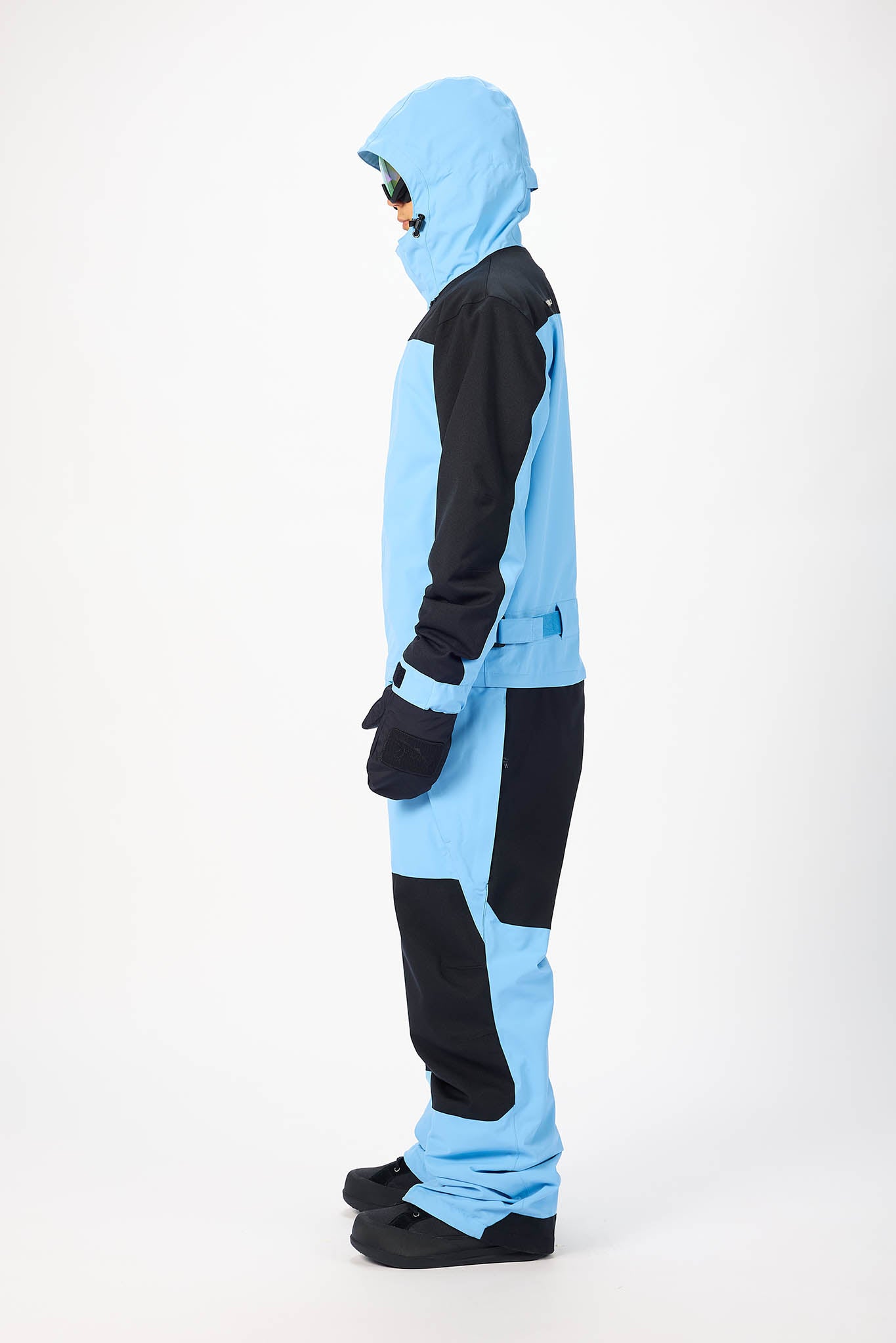 Person wearing a blue and black snowsuit on a white background