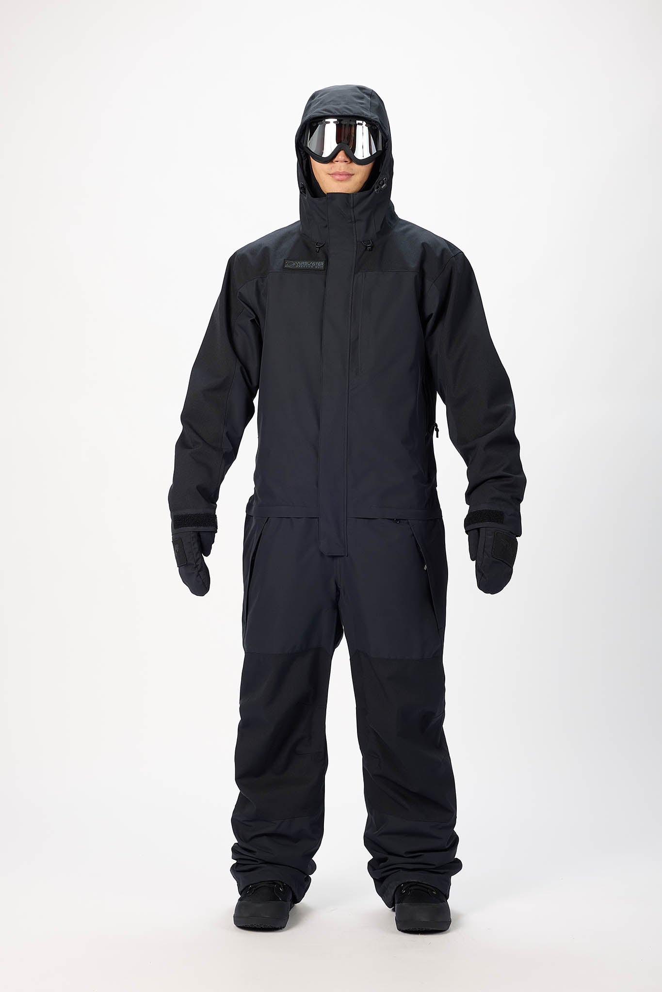 Person wearing a black snowmobile suit with goggles on a white background