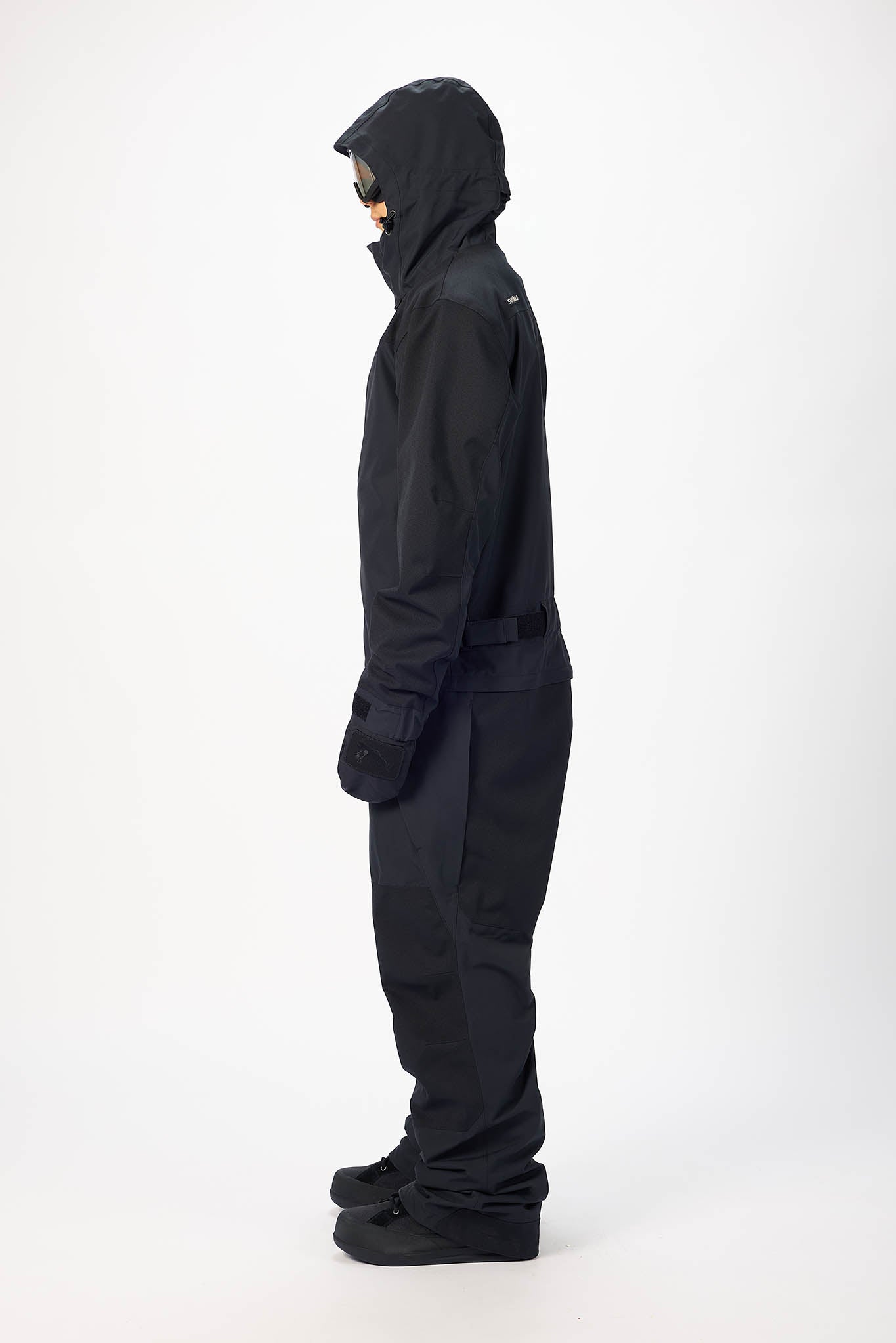 Person wearing a black snowsuit on a white background