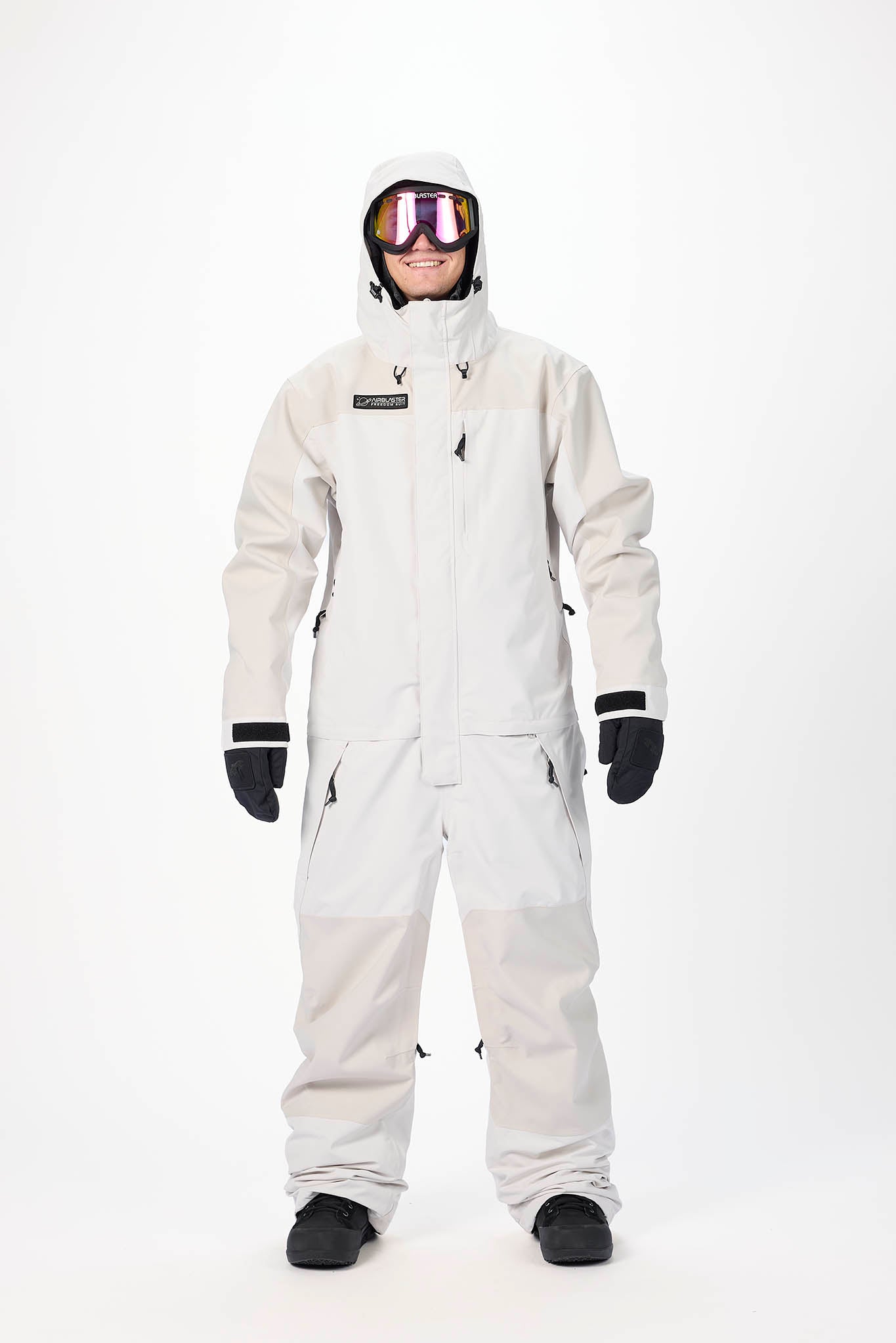 Person wearing a white snowsuit with goggles on a white background