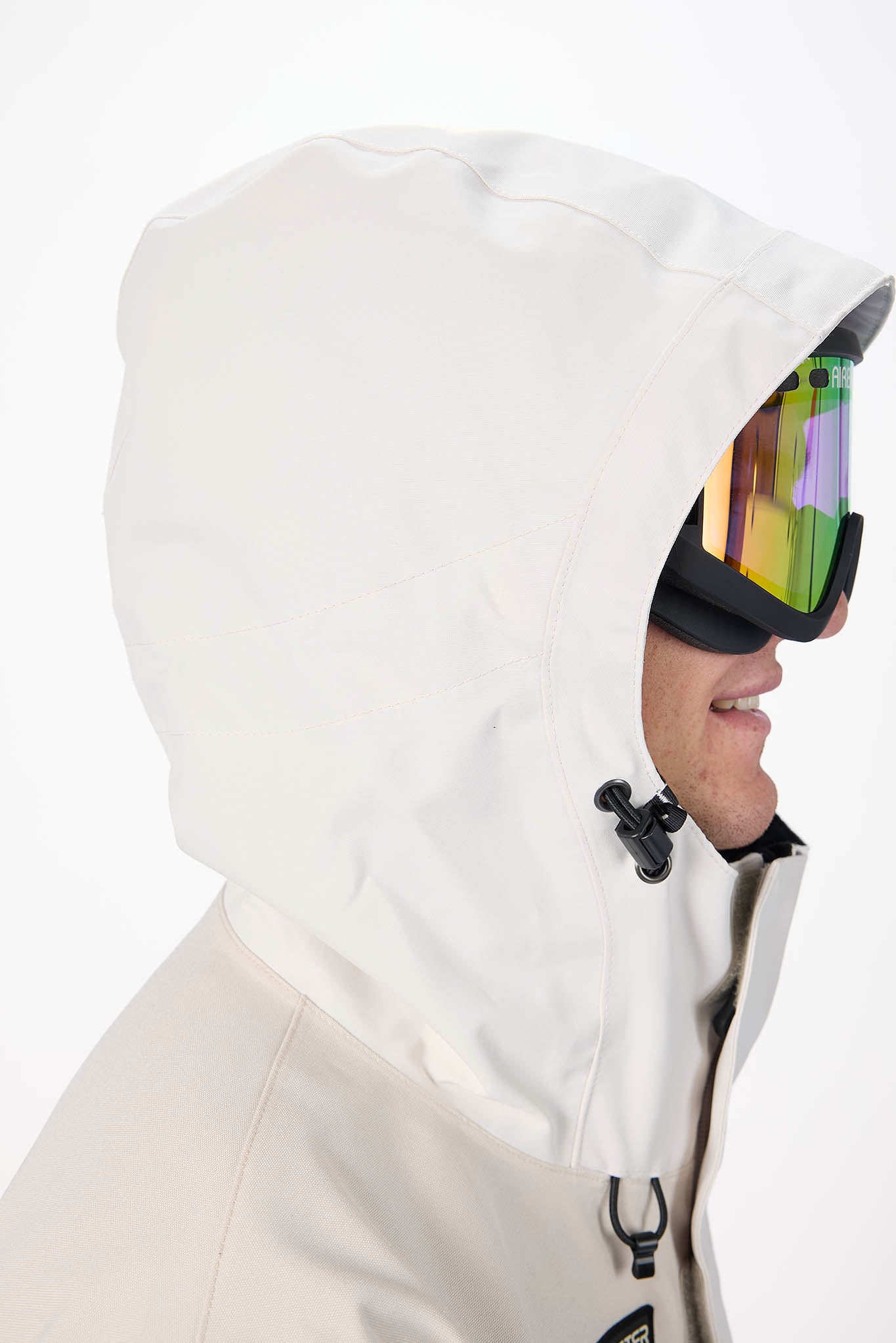 Person wearing a white hooded jacket with reflective goggles on a white background