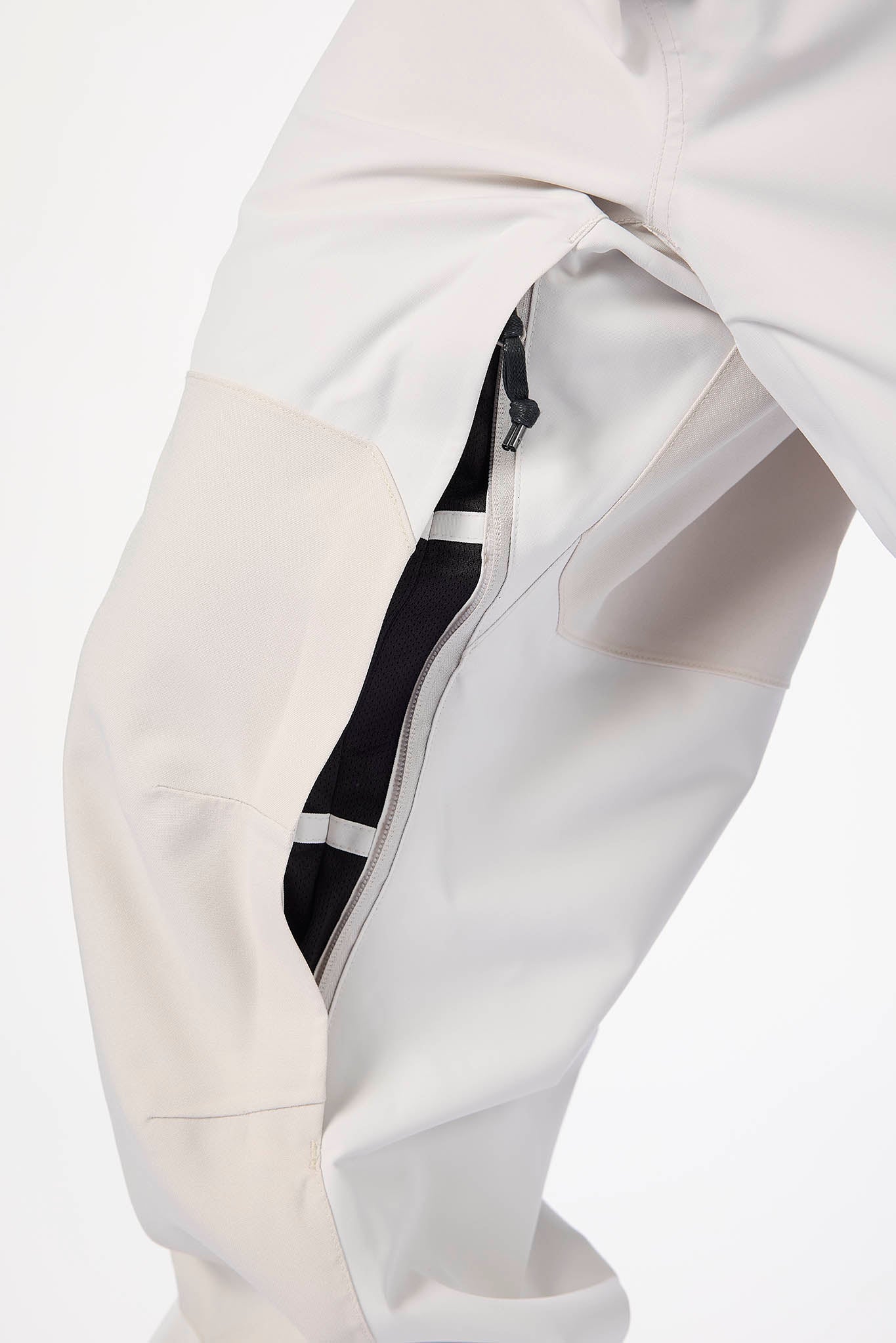 Close-up of a white jacket with a black zipper detail on a light gray background