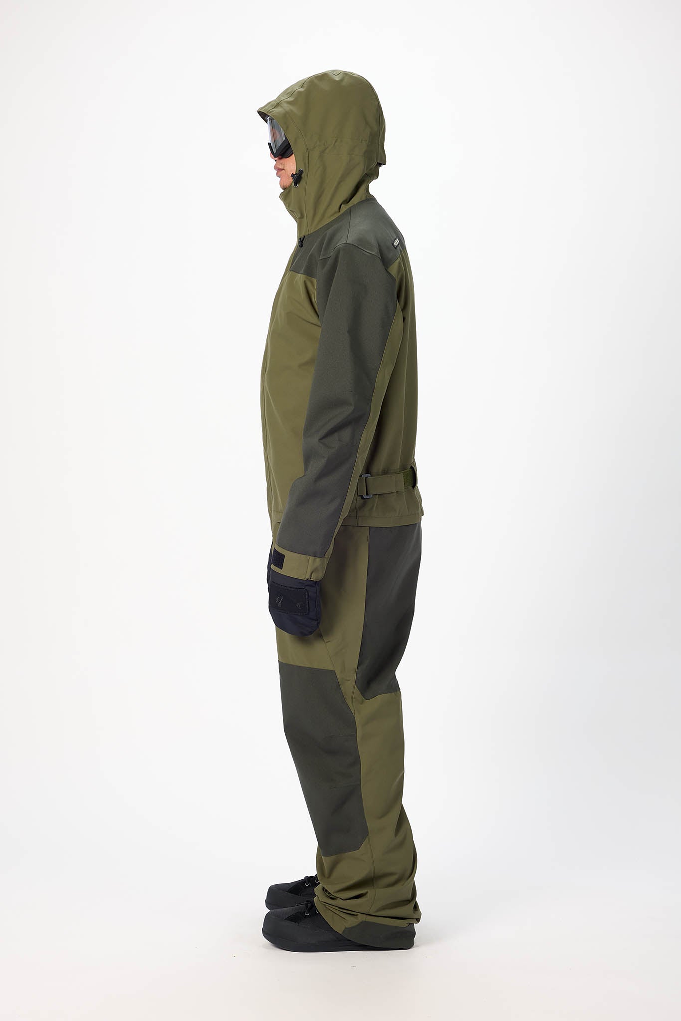 Person wearing a green and gray snowmobile suit on a white background