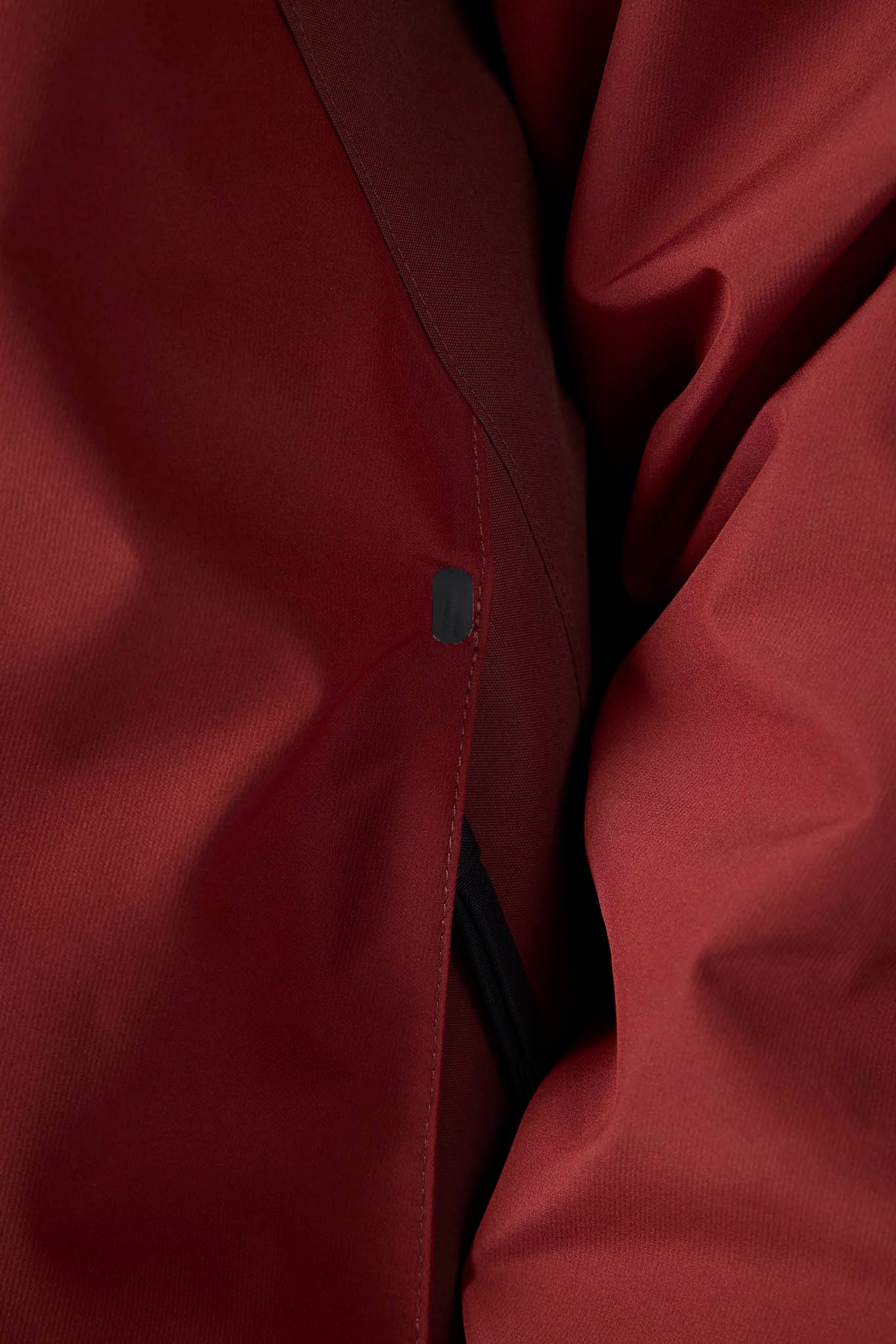 Close-up of a red jacket with a brand logo on a dark background
