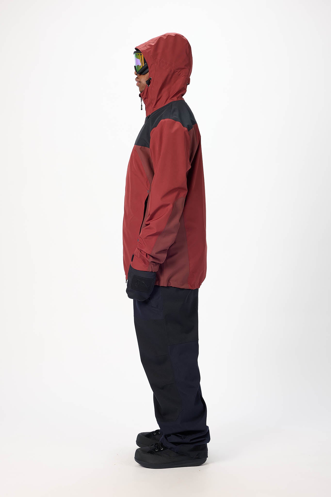 Person wearing a red and black snowsuit on a white background