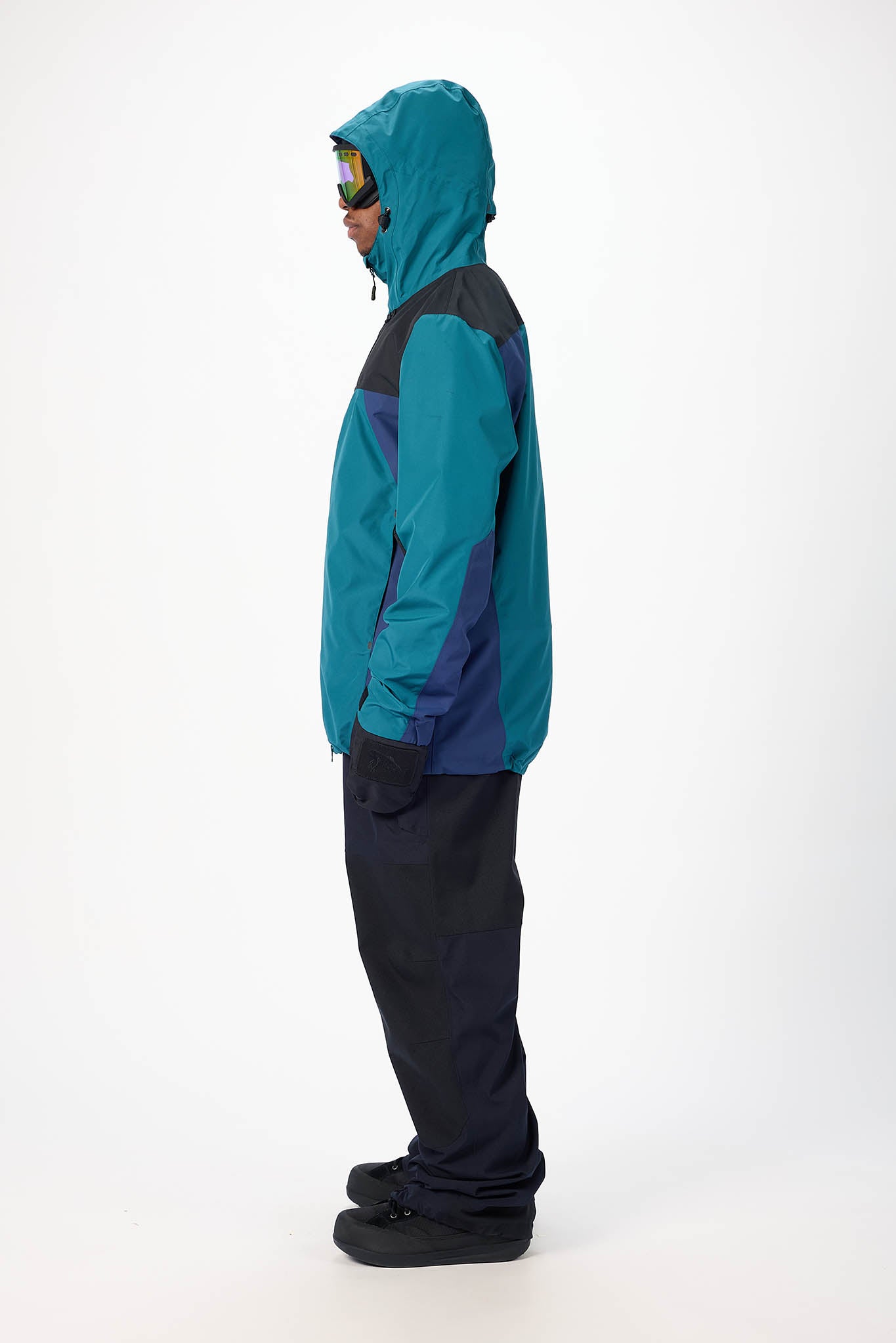 Person wearing a teal and black jacket on a white background