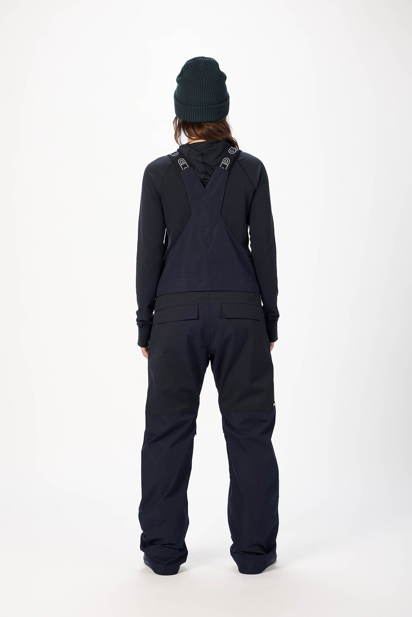 Person wearing a black snowsuit and beanie on a white background