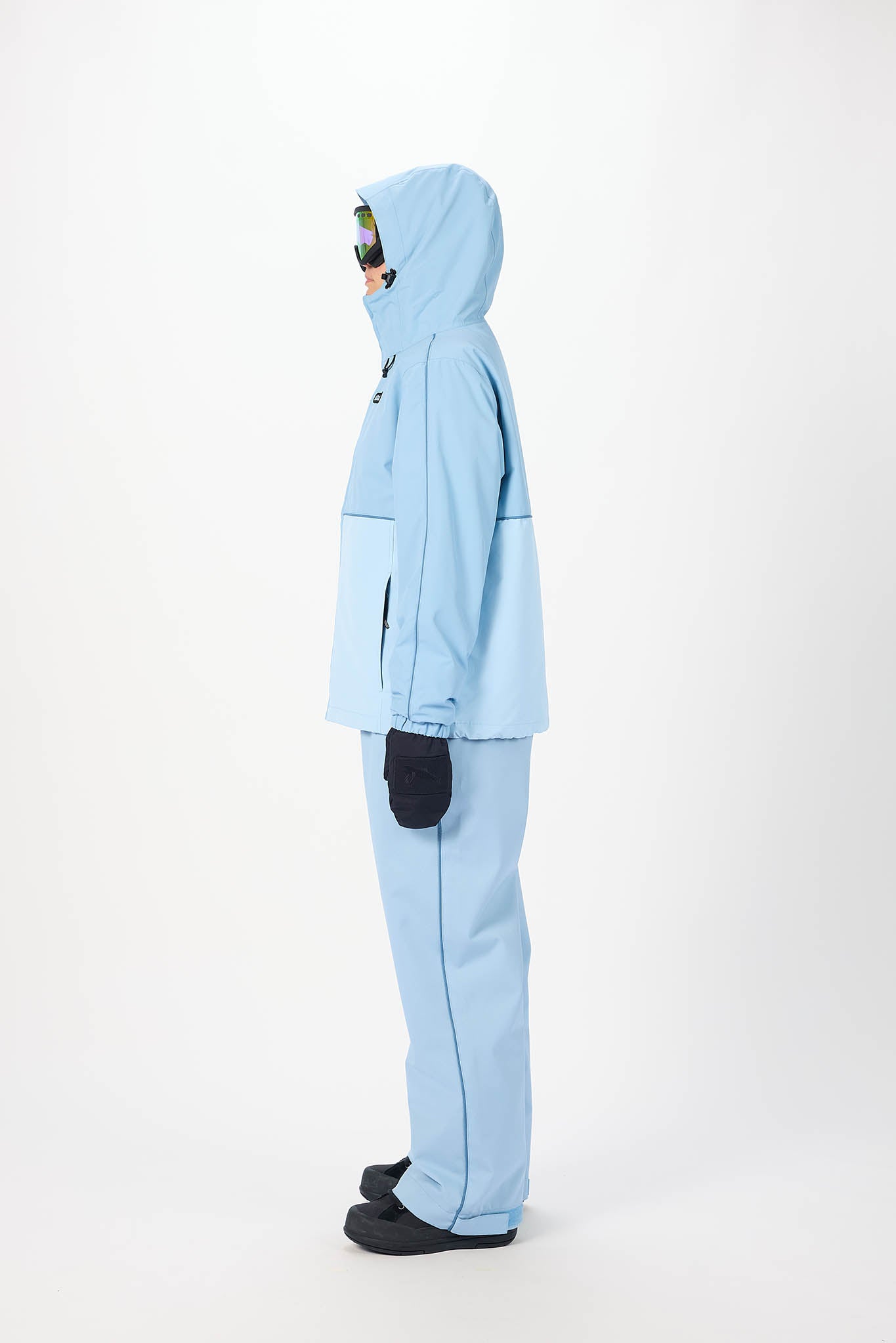 Person wearing a light blue snowsuit on a white background