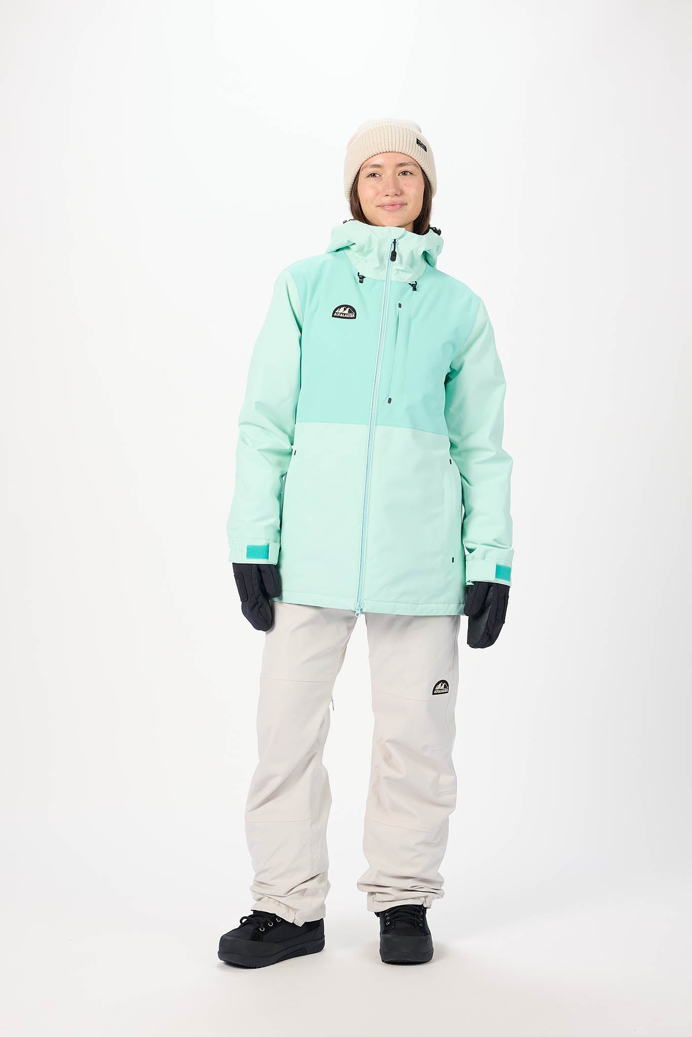 Person wearing a light blue snow jacket and pants on a white background