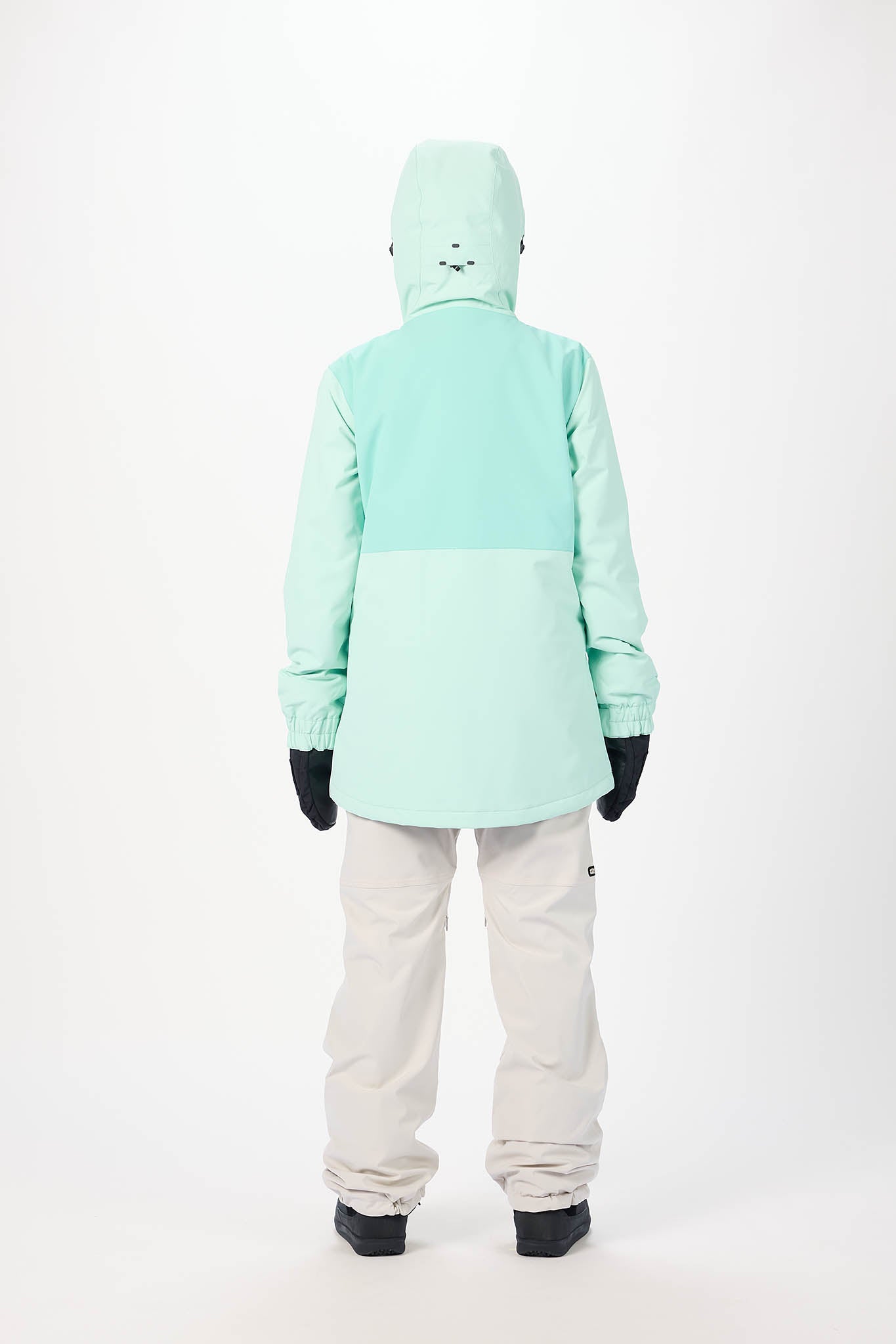Person wearing a light blue snow jacket and pants on a white background